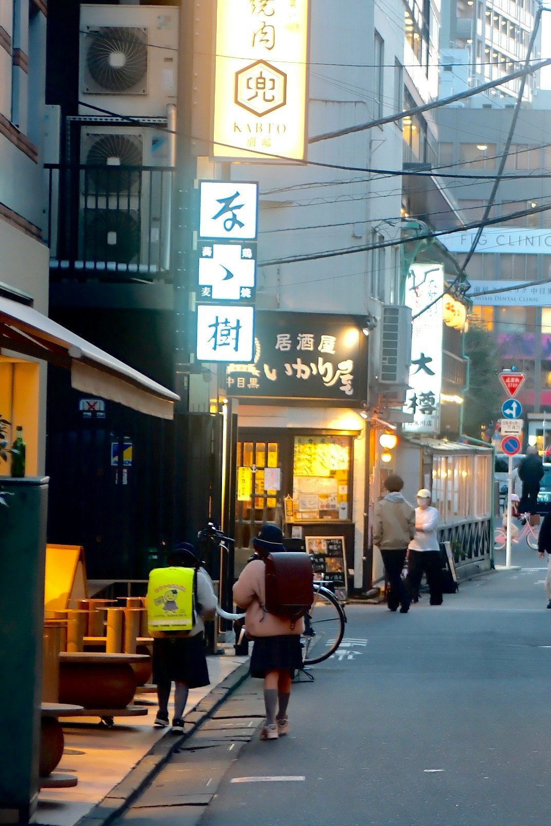 路地の飲食店の看板と人通りのある街角