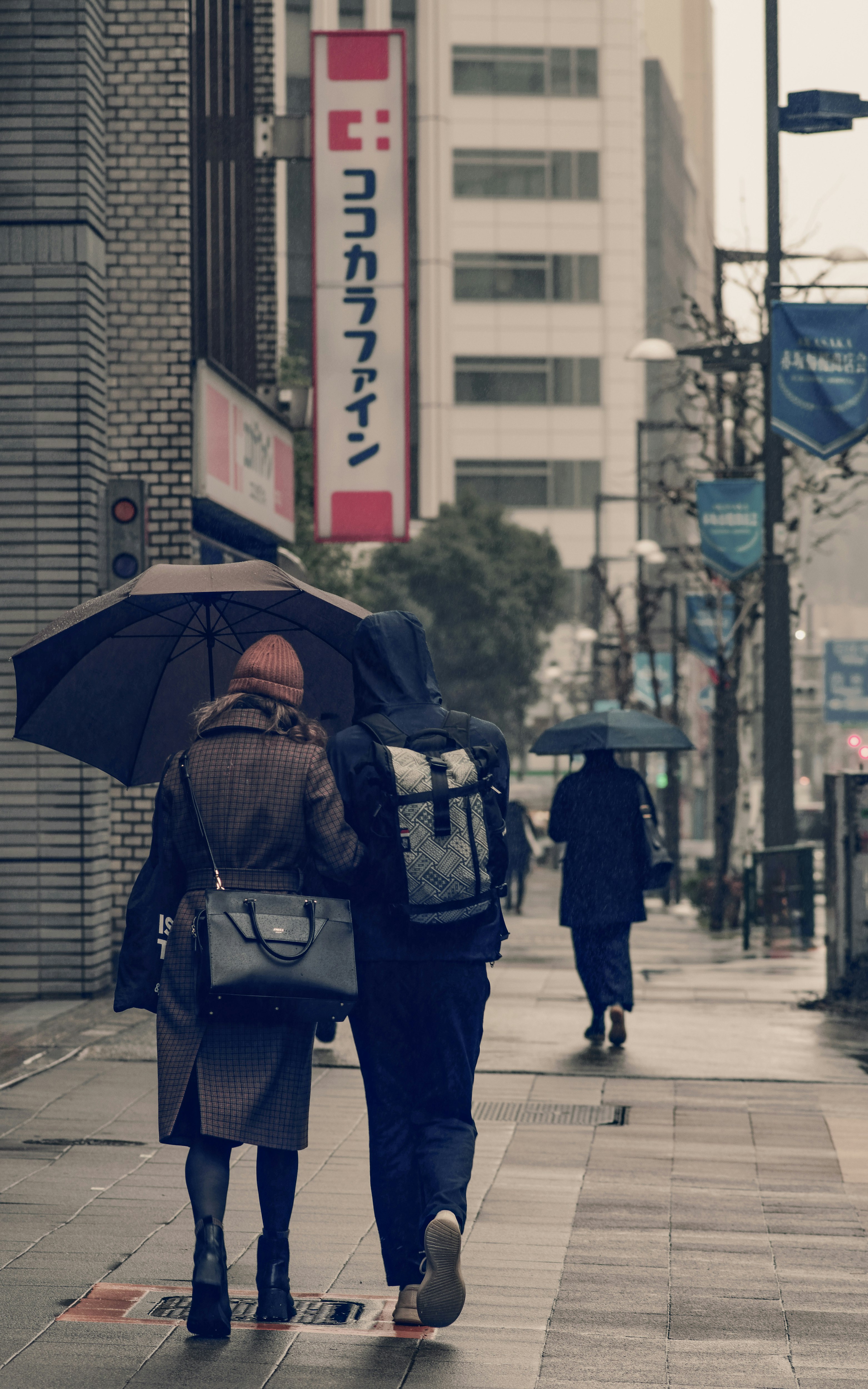 Commuters walking with umbrellas on a rainy morning street