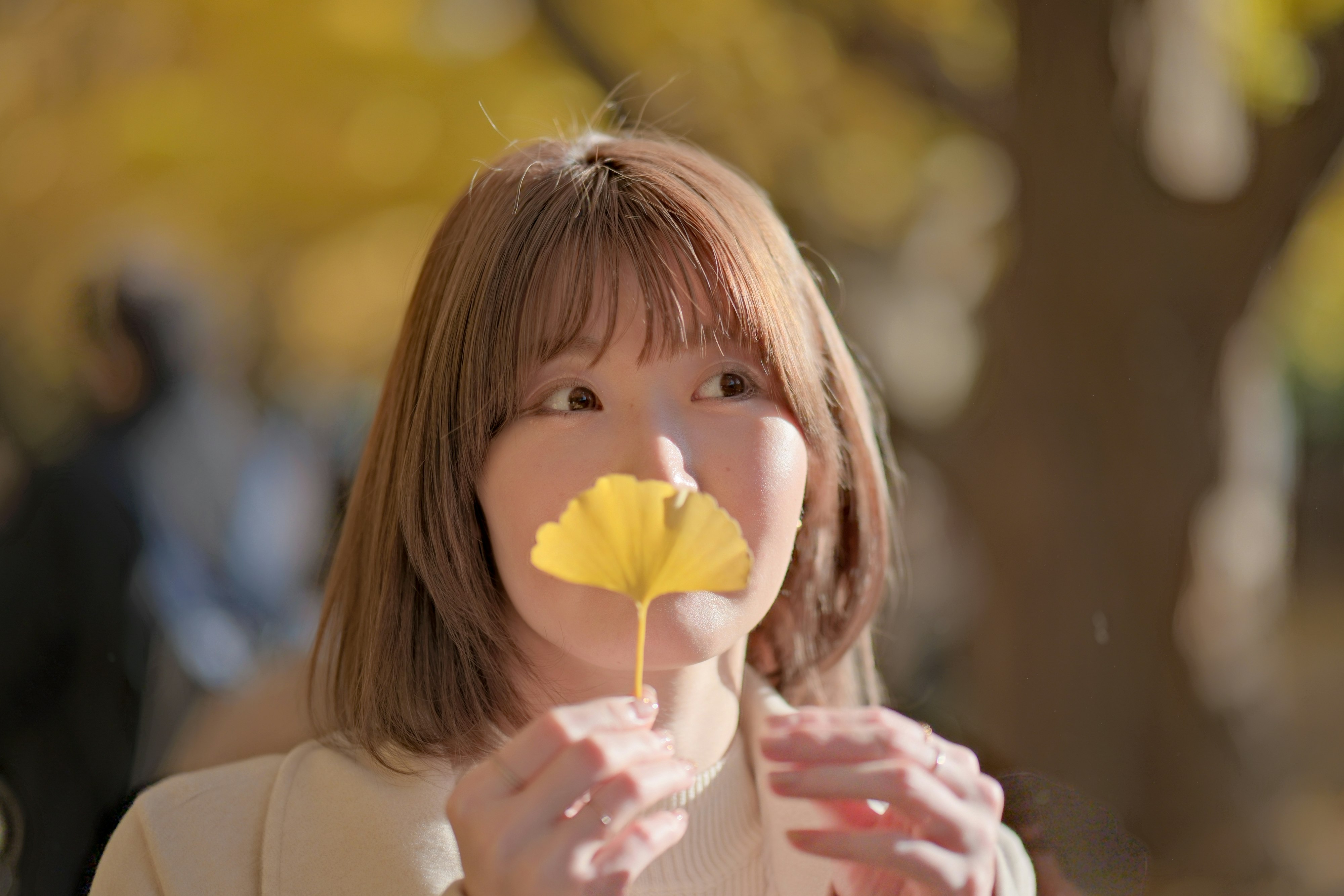 花びらを頬に当てる笑顔の女性