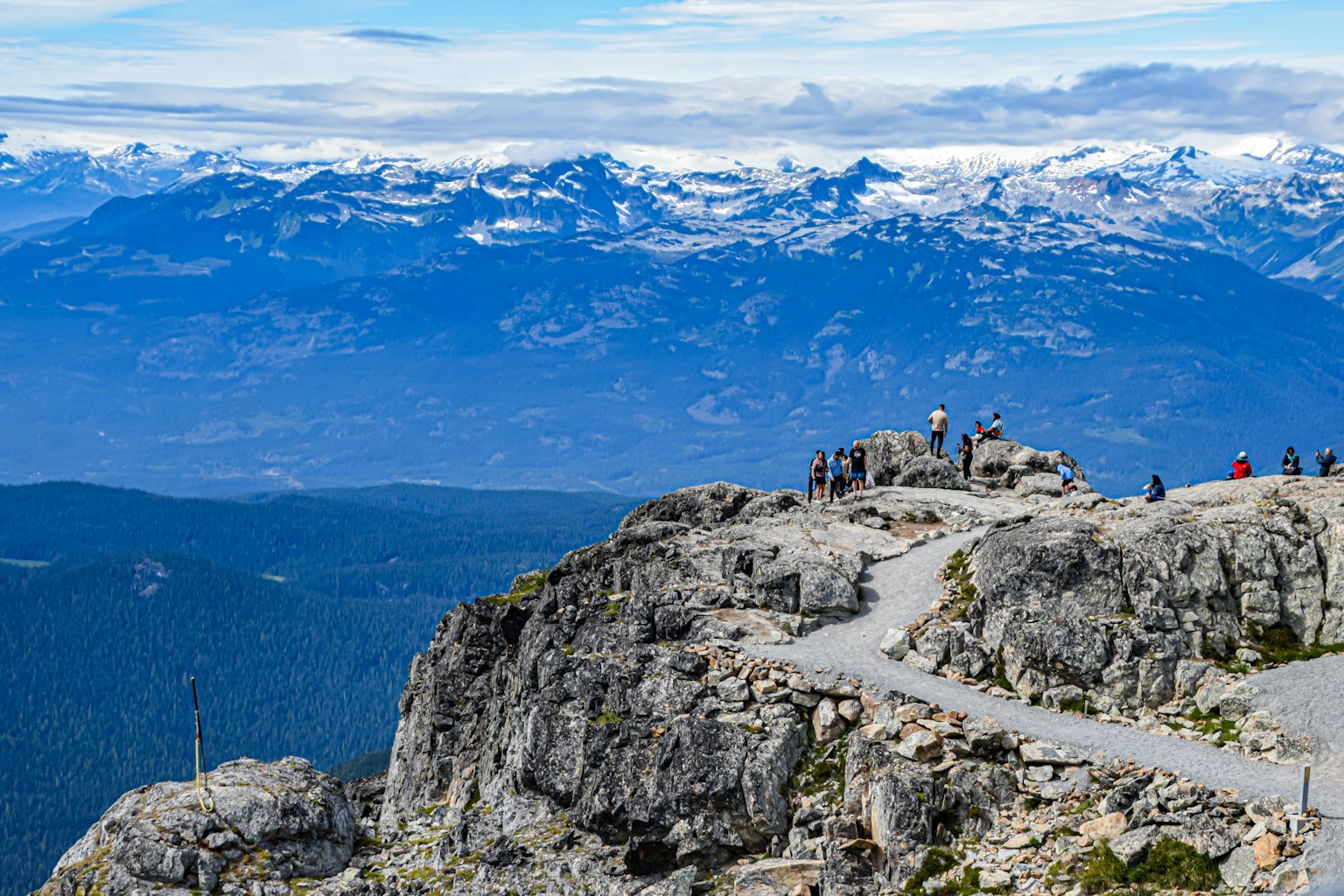 Turistas de pie en una roca con hermosas montañas y cielo azul