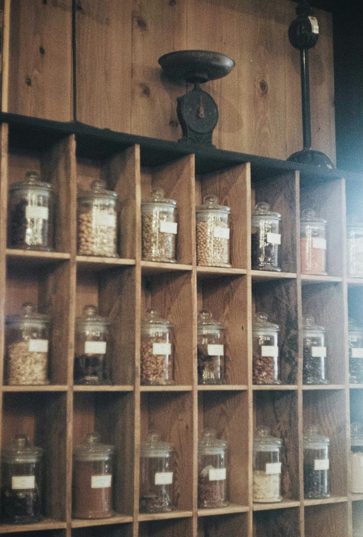 wooden shelves lined with glass jars of spices and dry goods