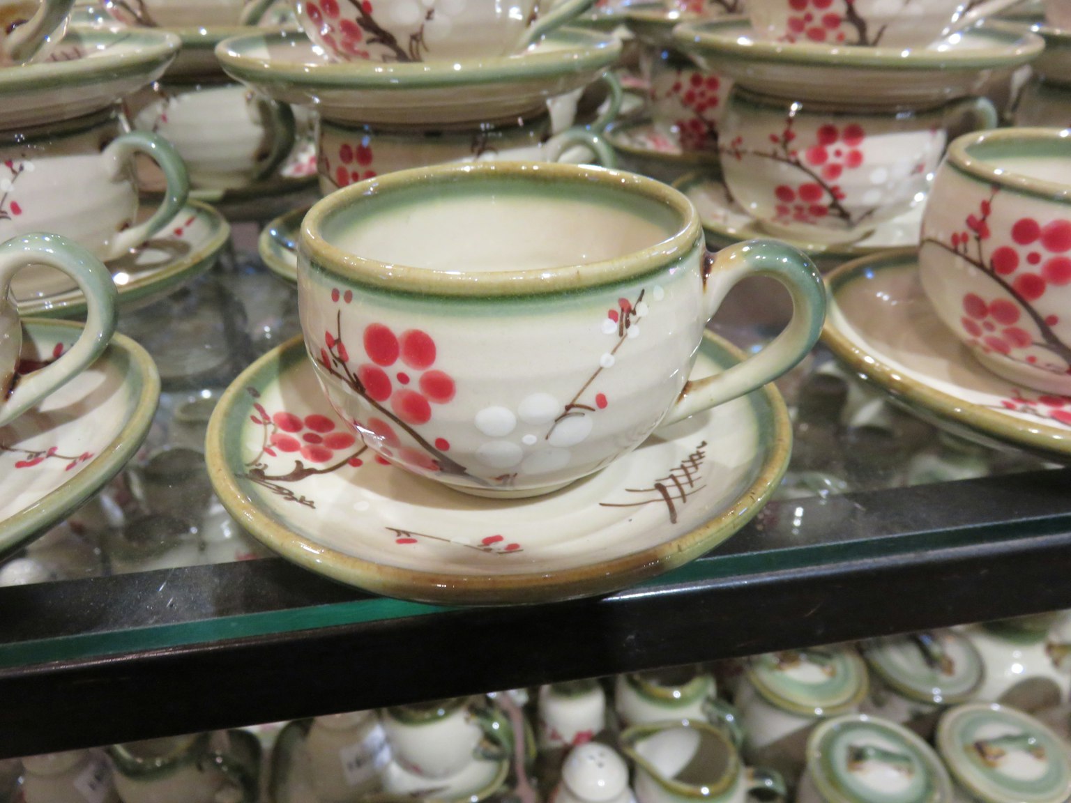 Zarte Blumenteetasse und Untertasse in einer Vitrine aus Glas ausgestellt