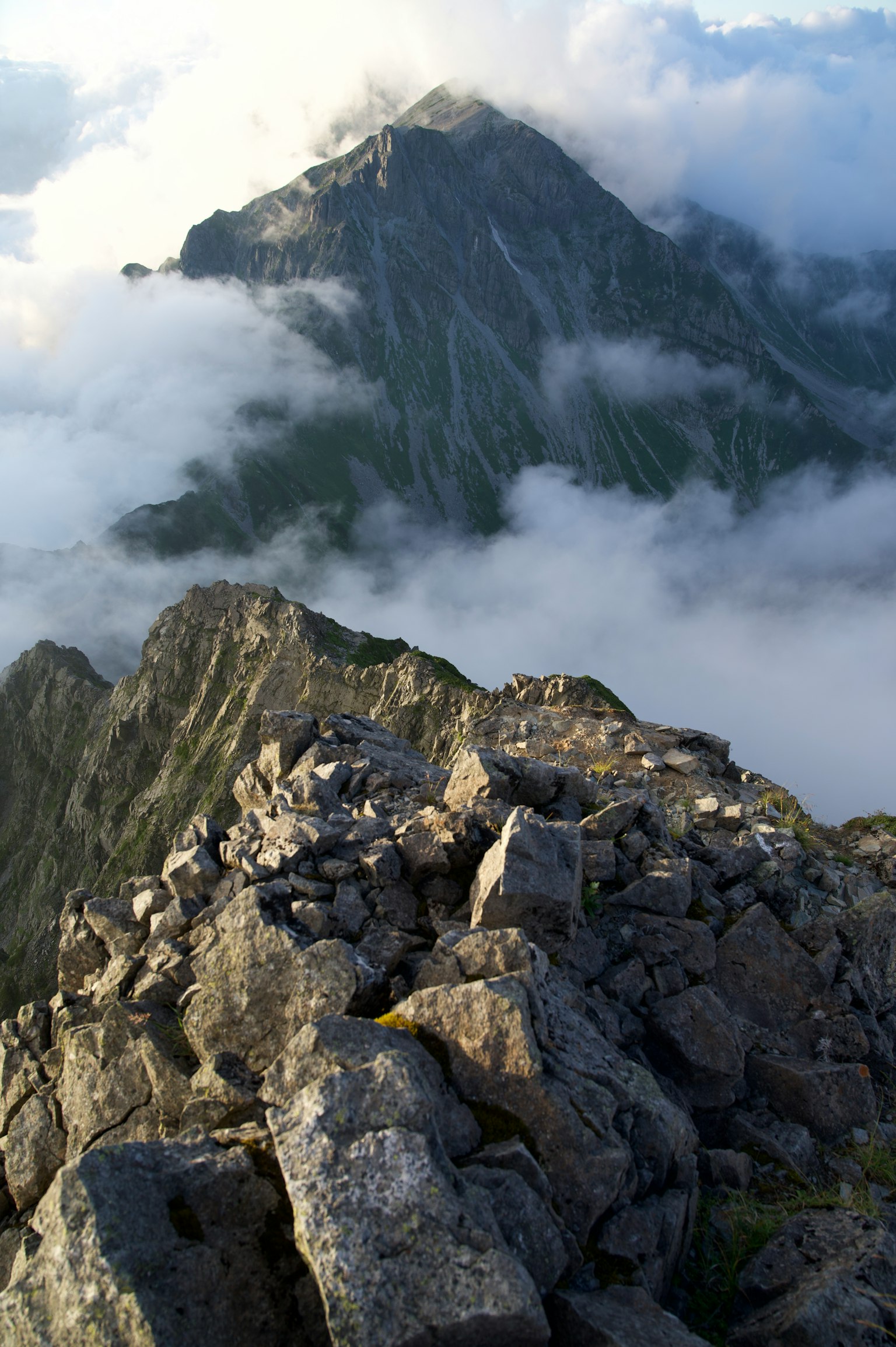Scenic view from mountain peak featuring rocky terrain and clouds