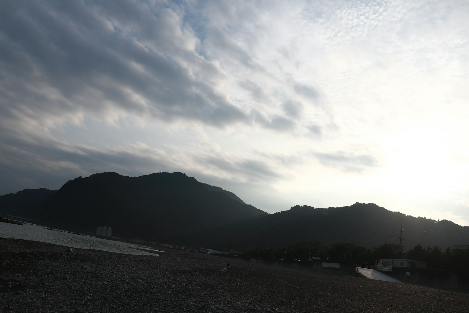 宁静的海岸线与云雾下的山脉轮廓