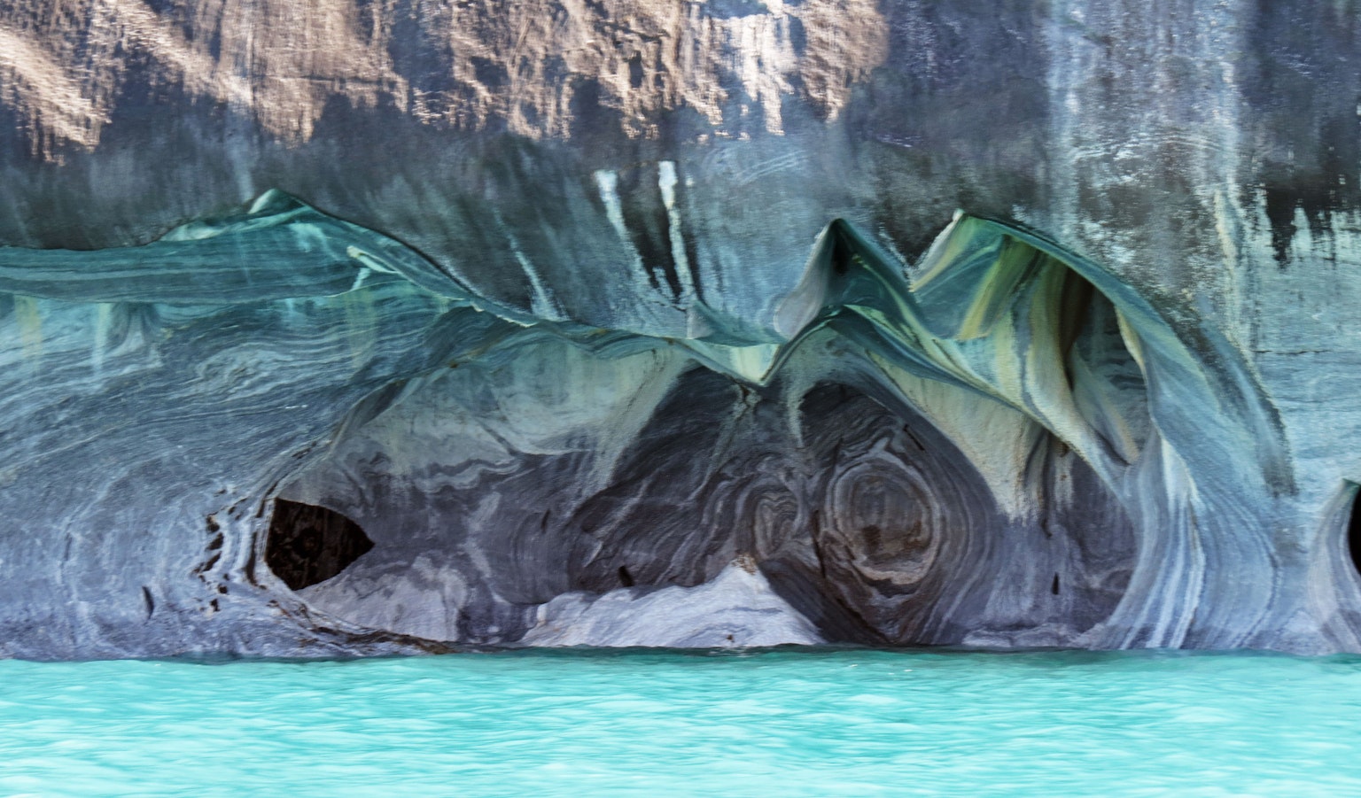 Einzigartige Felsformationen in einer Höhle über türkisfarbenem Wasser