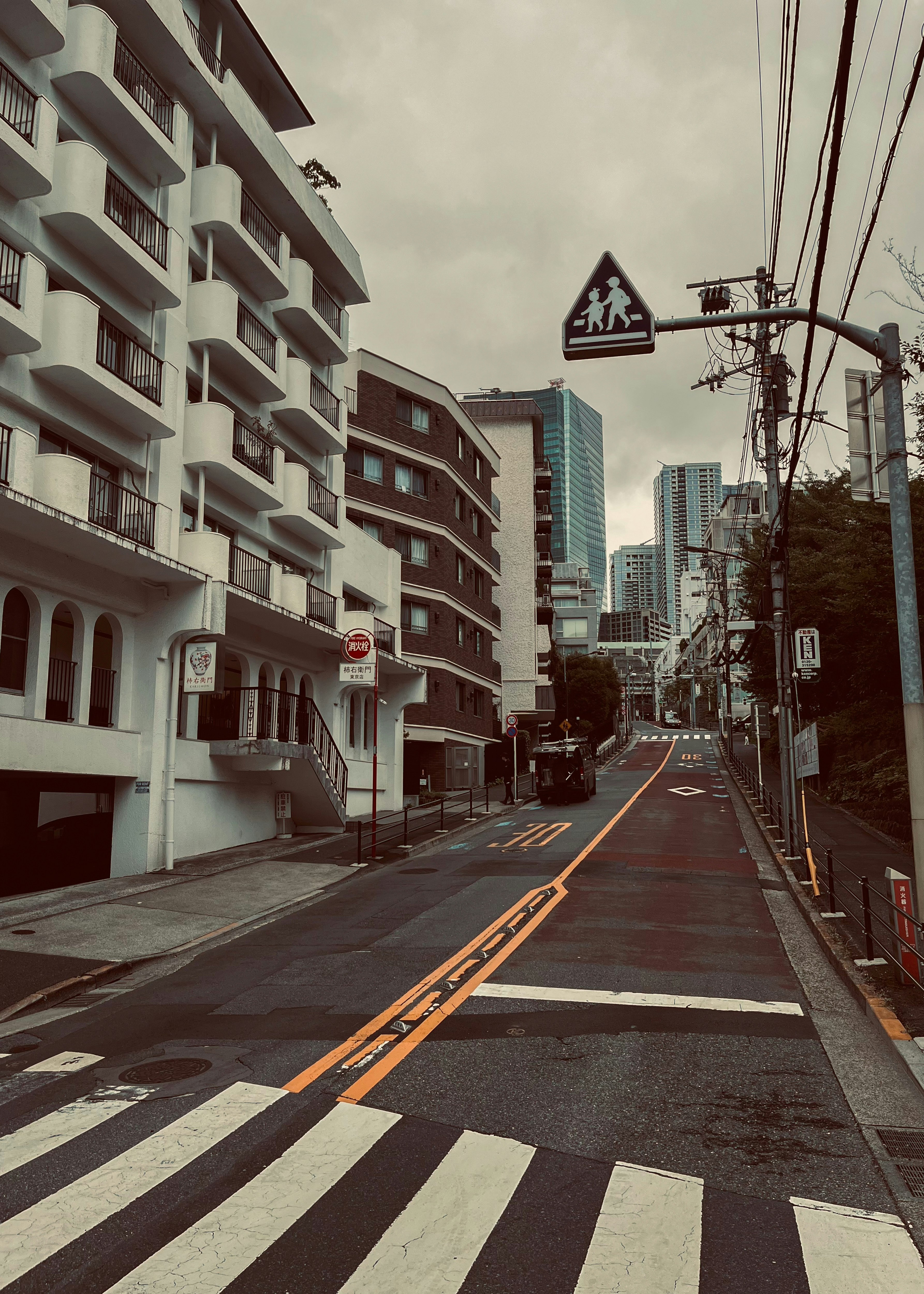 路地に面した建物と高層ビルが見える街並み