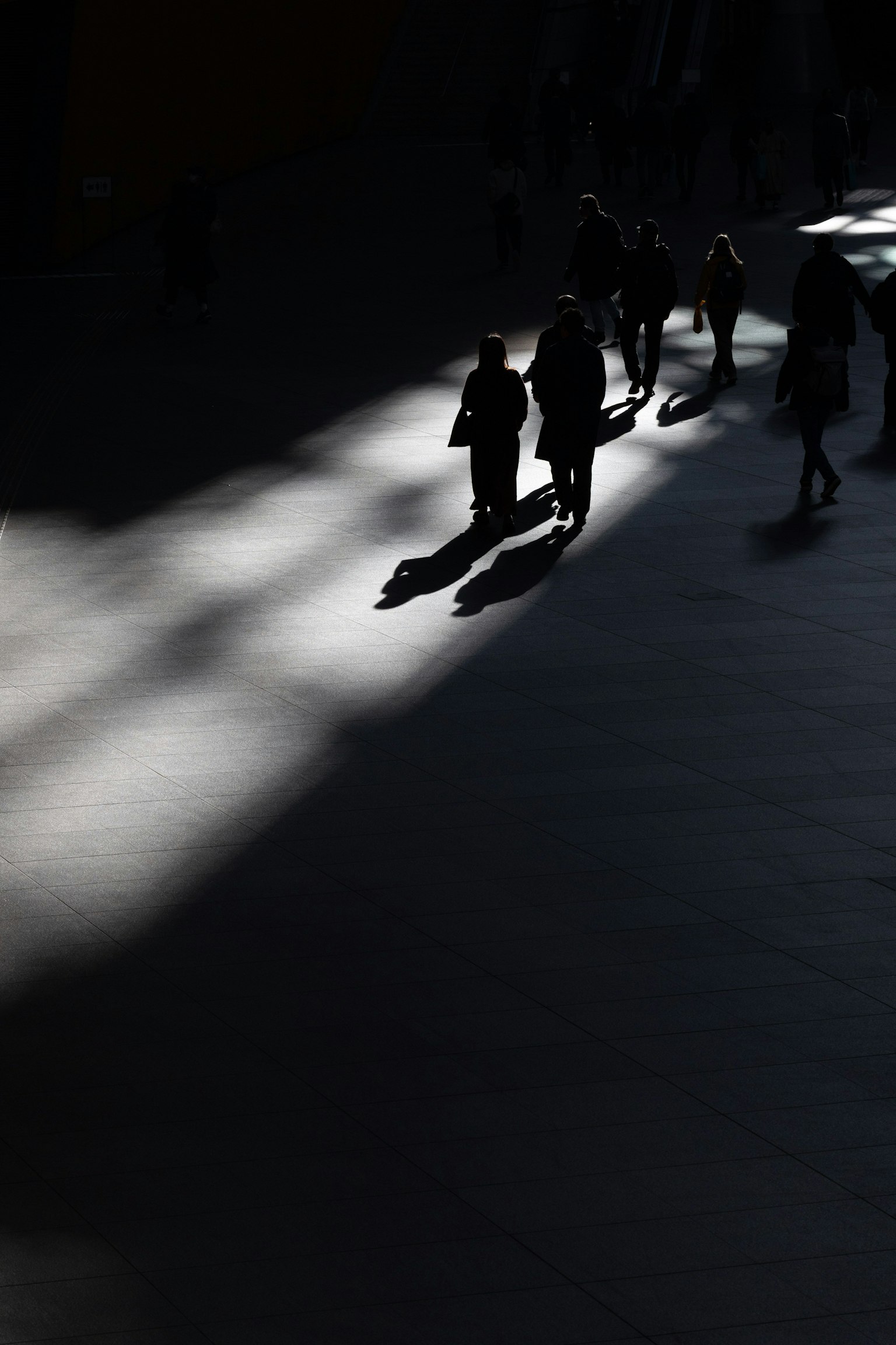 เงาของคนที่เดินอยู่ในเงาบนพื้นหลังมืด