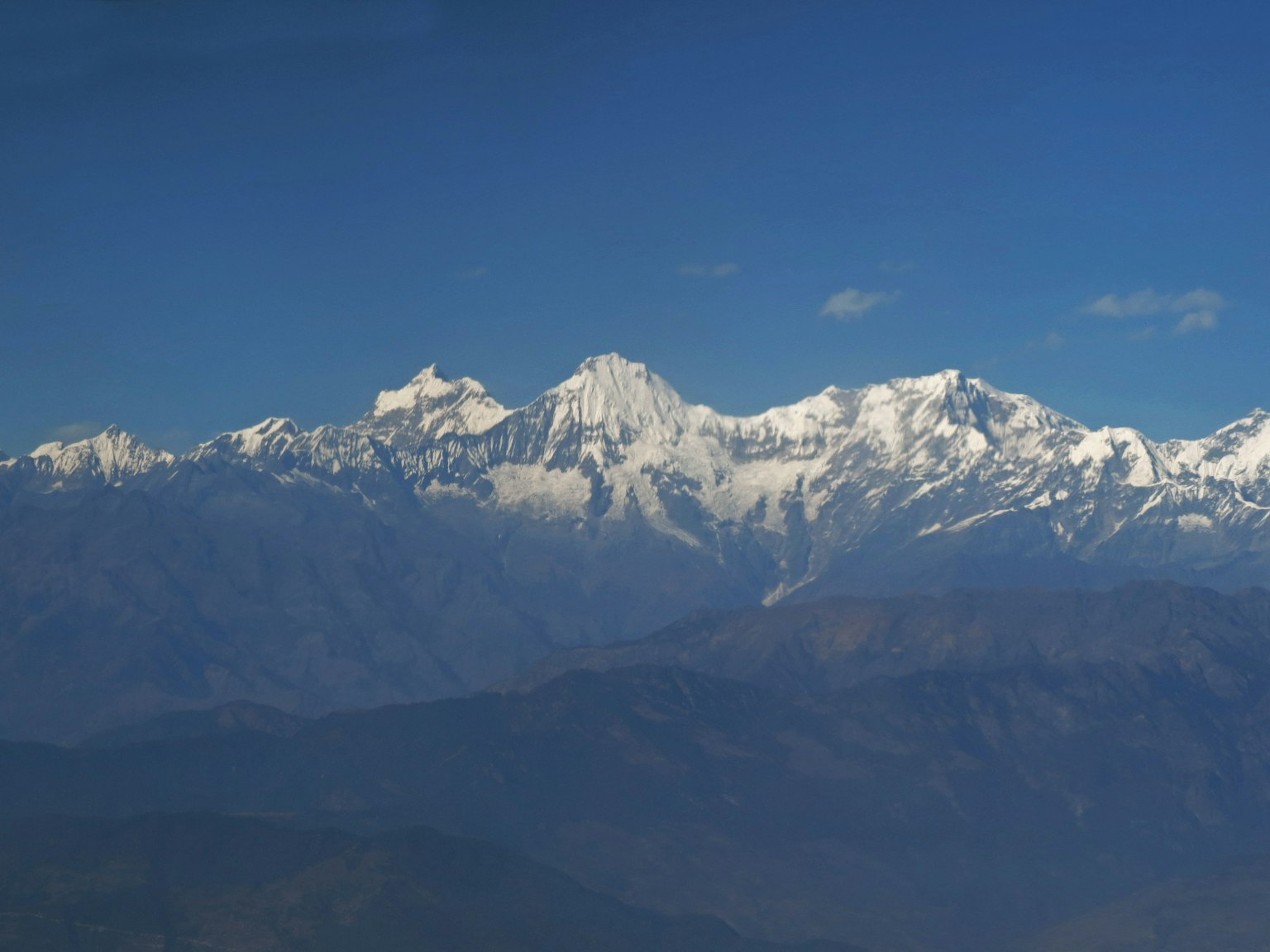 Chaîne de montagnes enneigées sous un ciel bleu clair