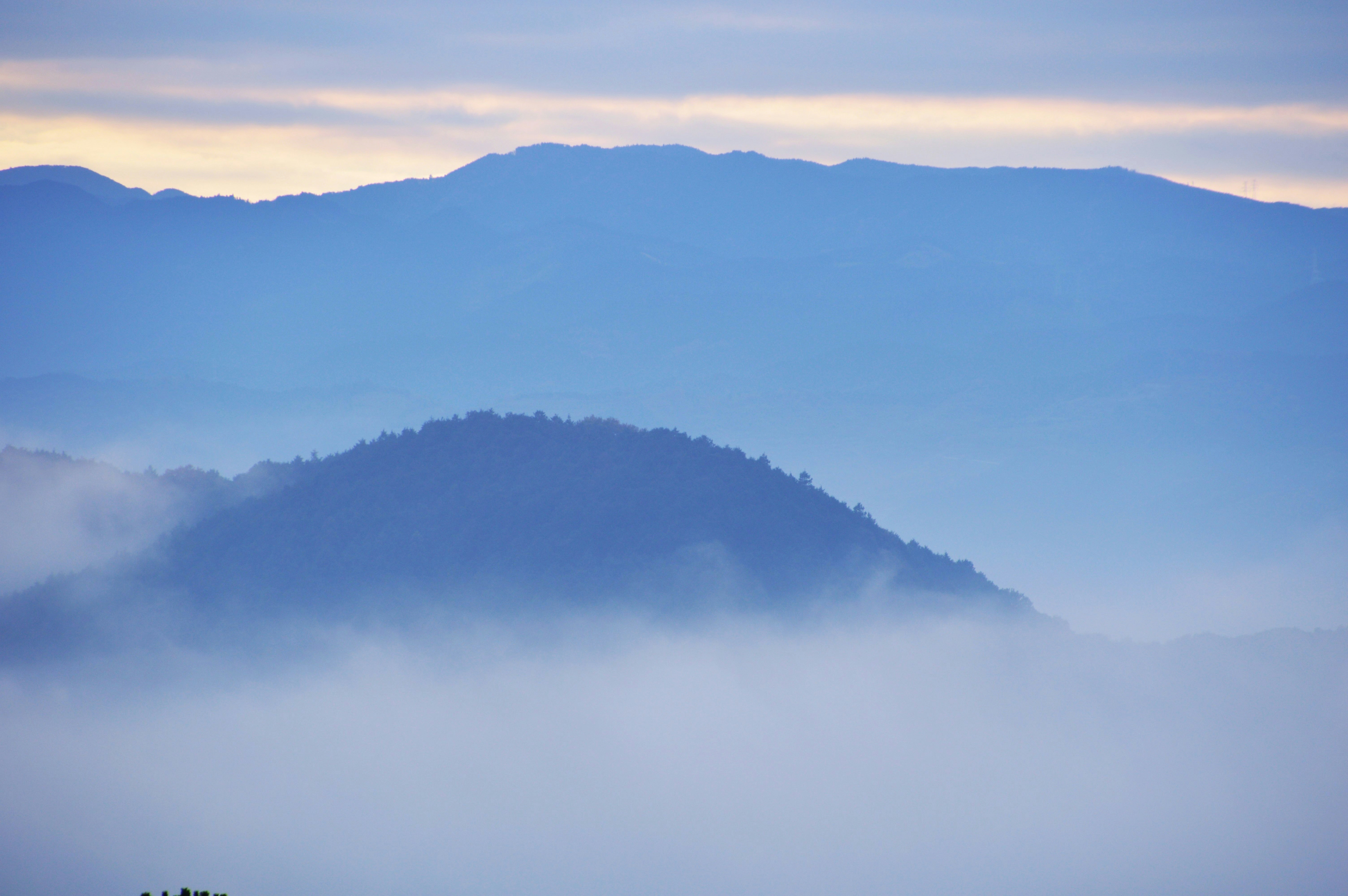 青い山並みと霧に包まれた谷の風景