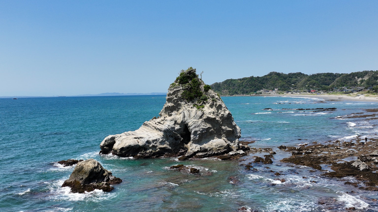 Pemandangan pantai yang indah dengan lautan biru dan formasi batu