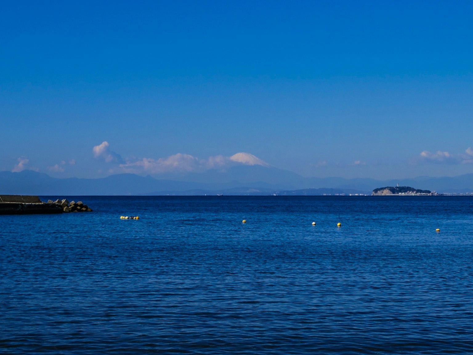 Vue panoramique de l'océan bleu et du ciel avec une île et des bouées blanches