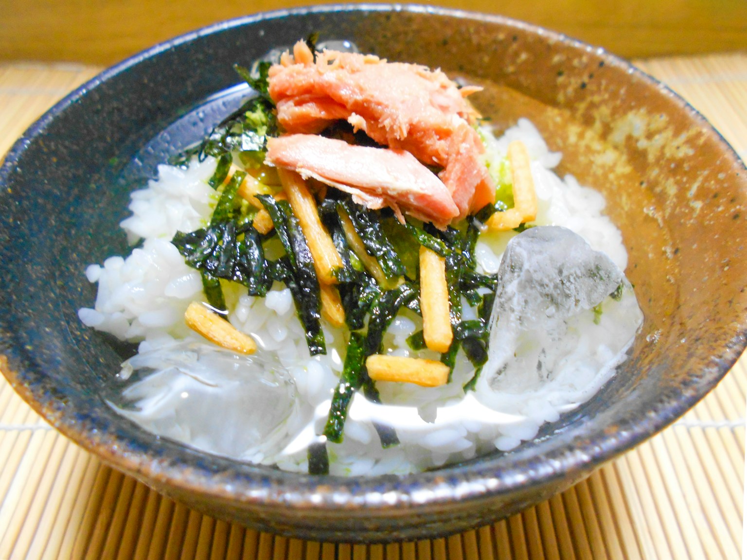 Un bol de riz surmonté d'algues et de poulet dans un style japonais