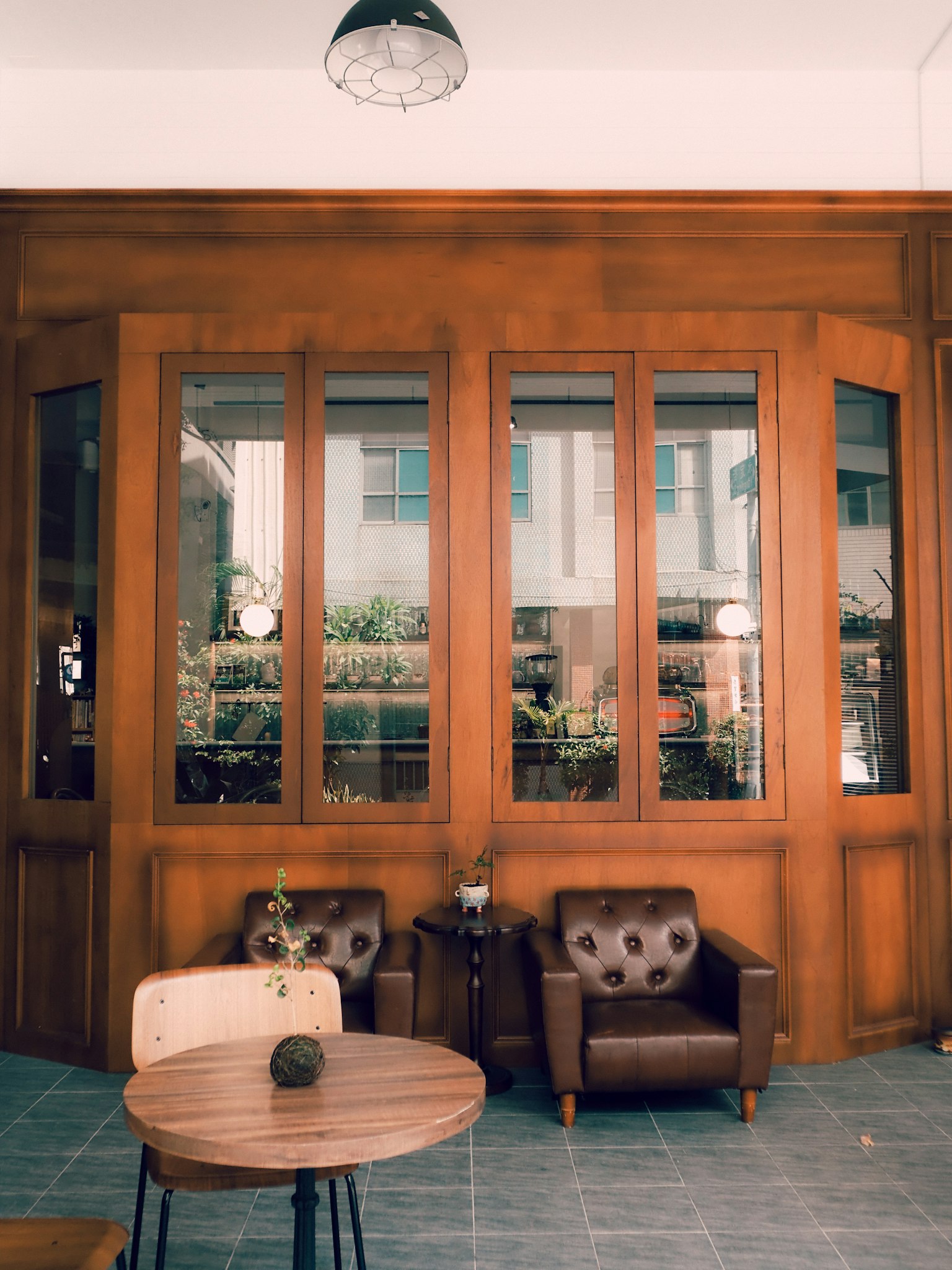 Interior de una cafetería con paredes y ventanas de madera con una mesa y sillas