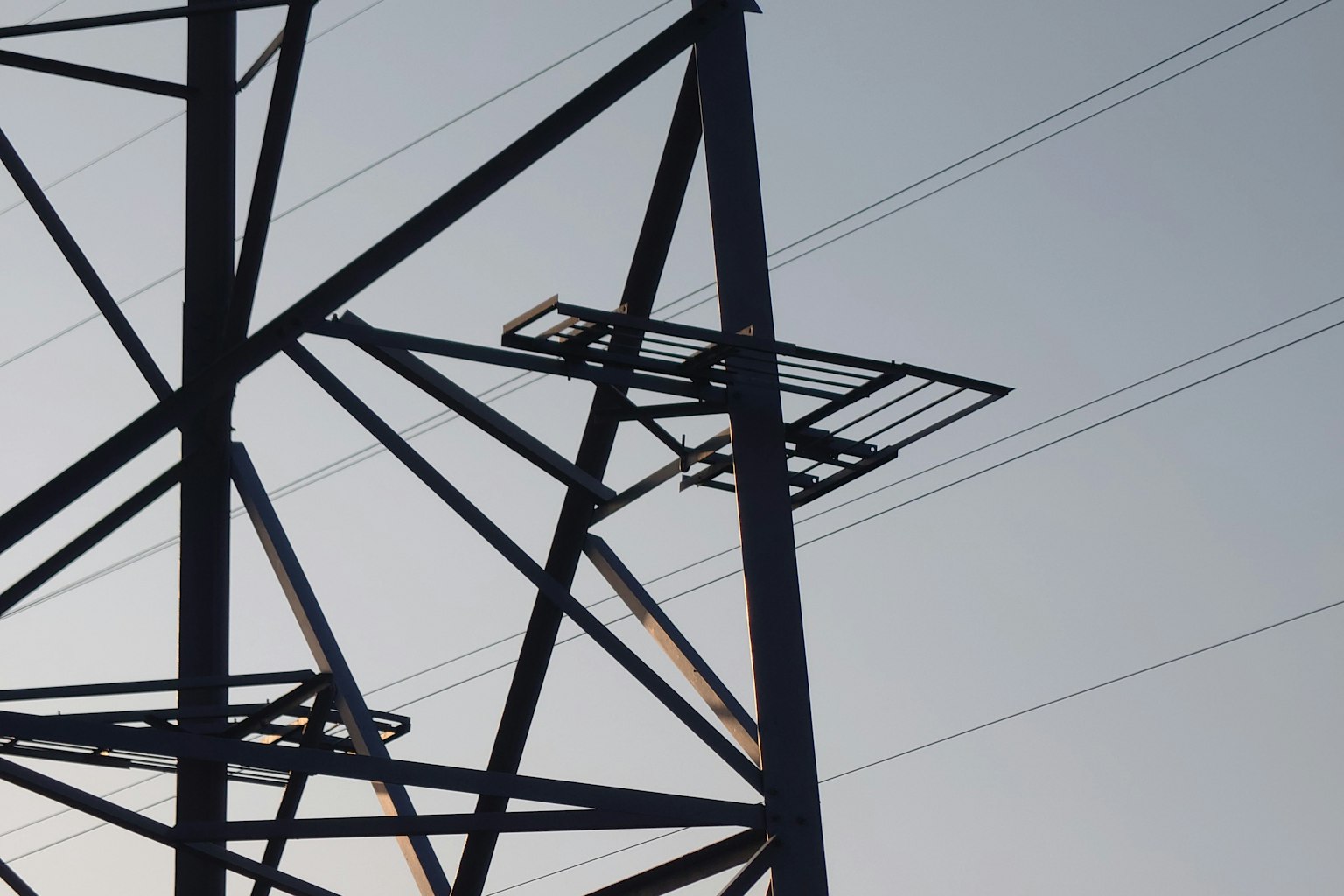 Silhouette di una torre elettrica contro un cielo sfumato