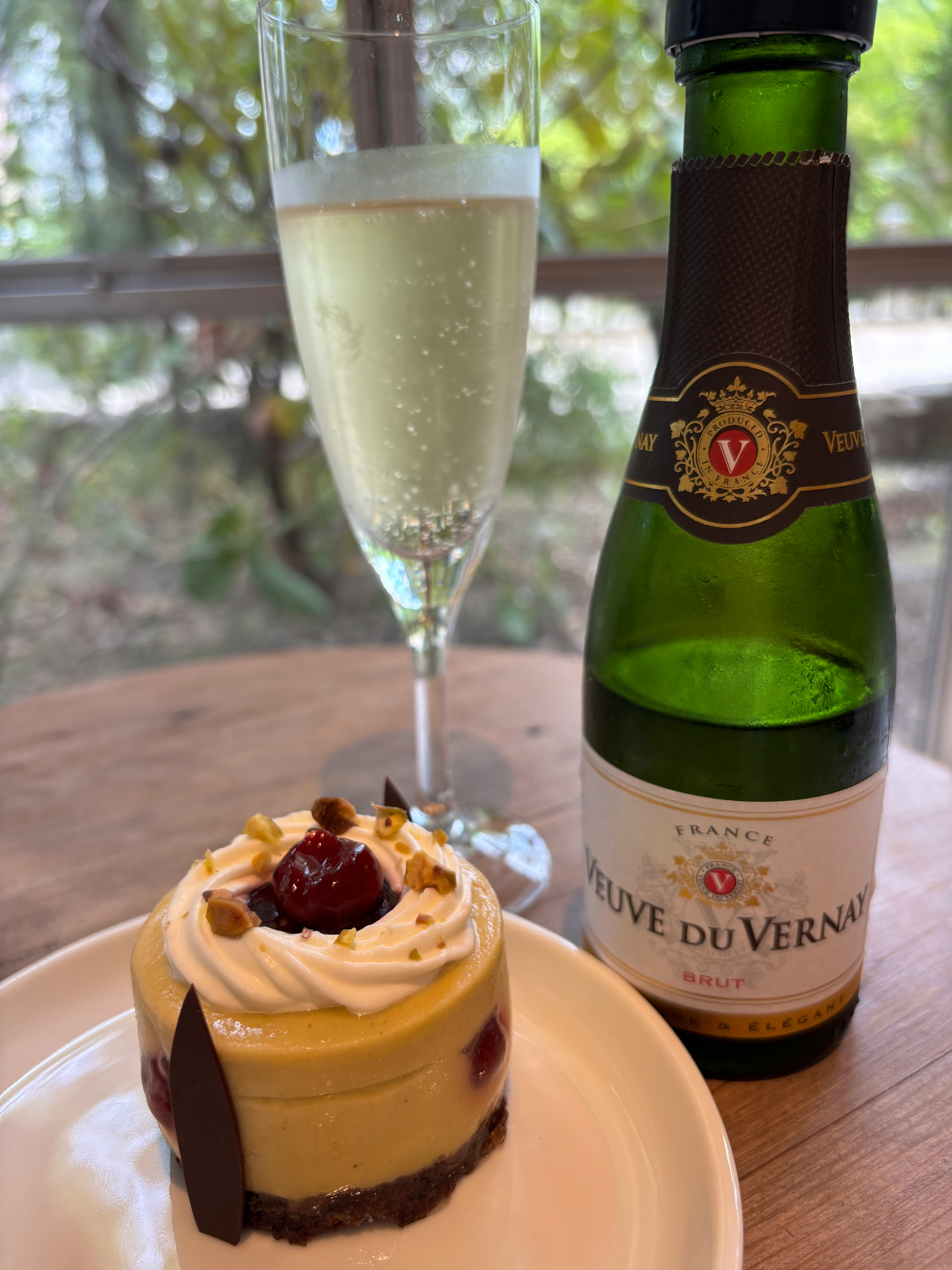 グラスシャンパンとケーキのあるカフェテーブル