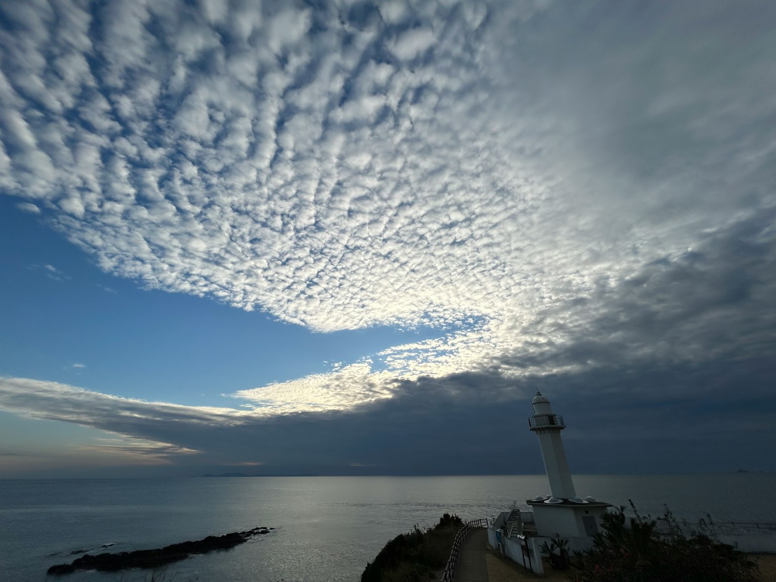 Vue pittoresque d'un phare au bord de la mer sous un ciel dramatique