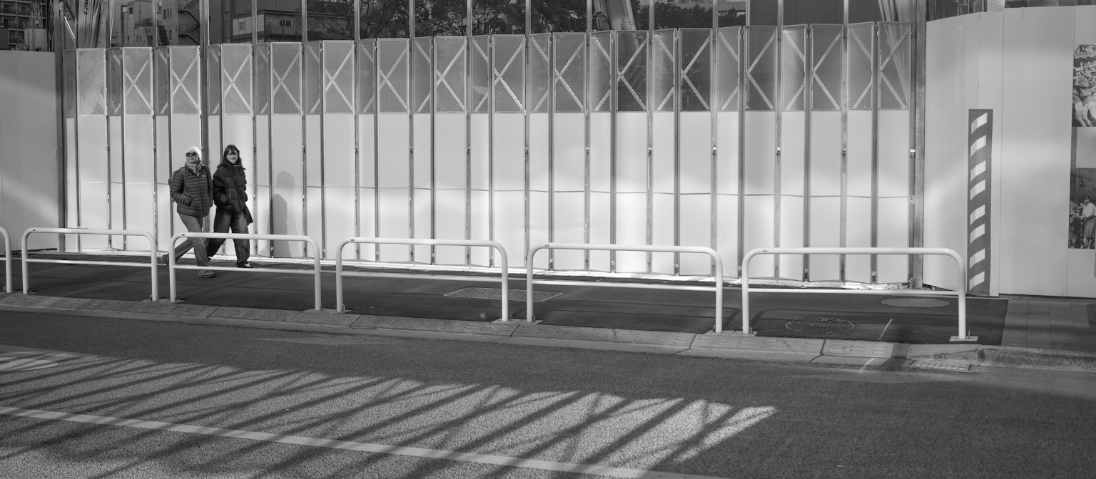 Due persone che camminano fianco a fianco in un contesto in bianco e nero