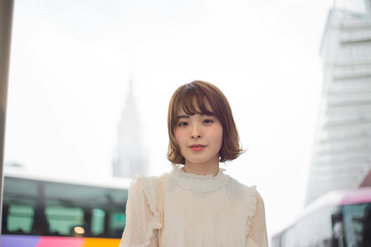 一位穿着浅色衬衫的女性站在城市环境中