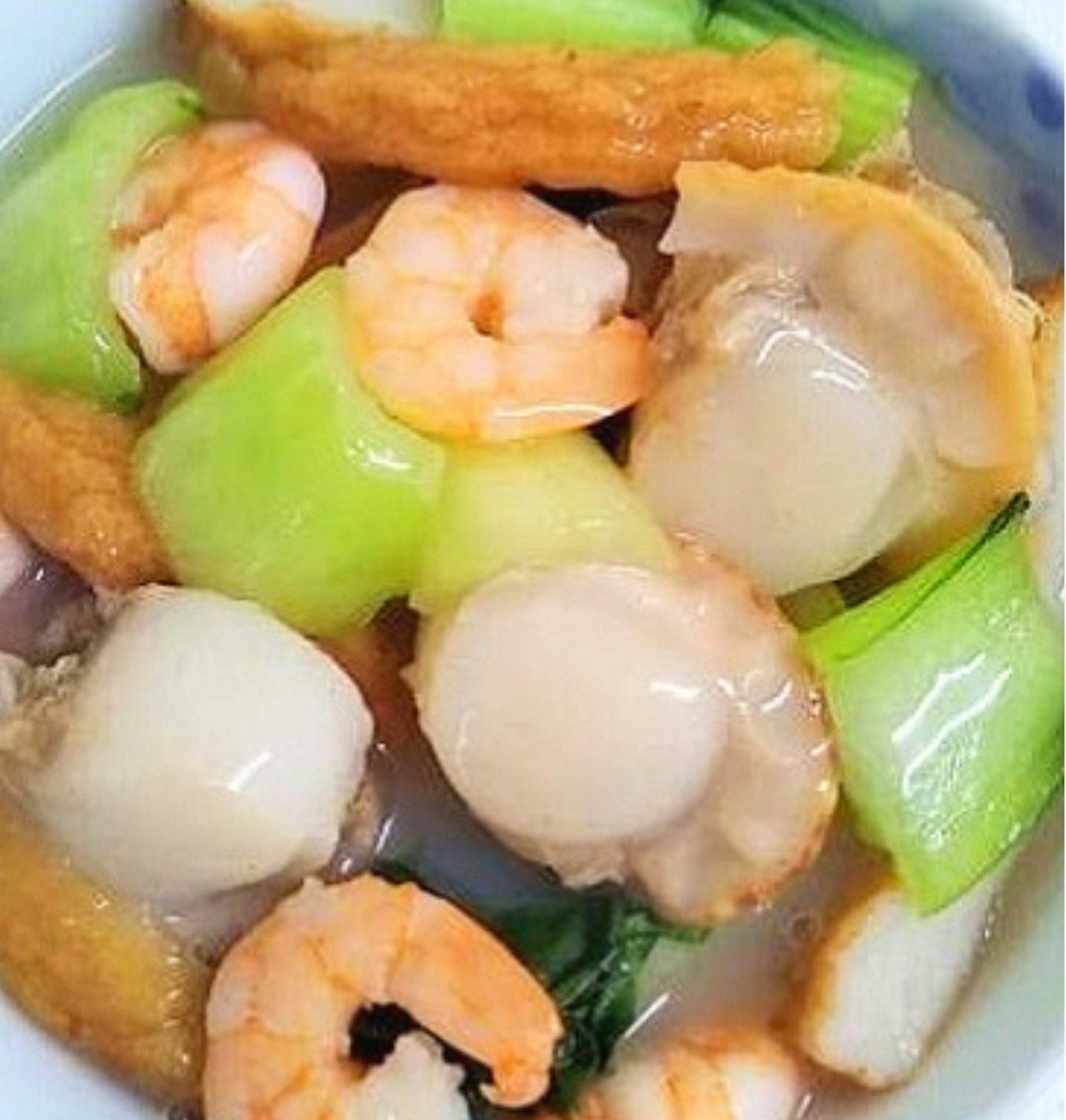 จานผัดที่มีกุ้ง, หอยเชลล์, และผักสีเขียว
