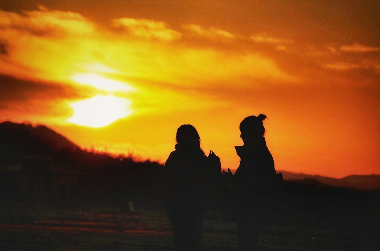 夕阳下两人对话的轮廓
