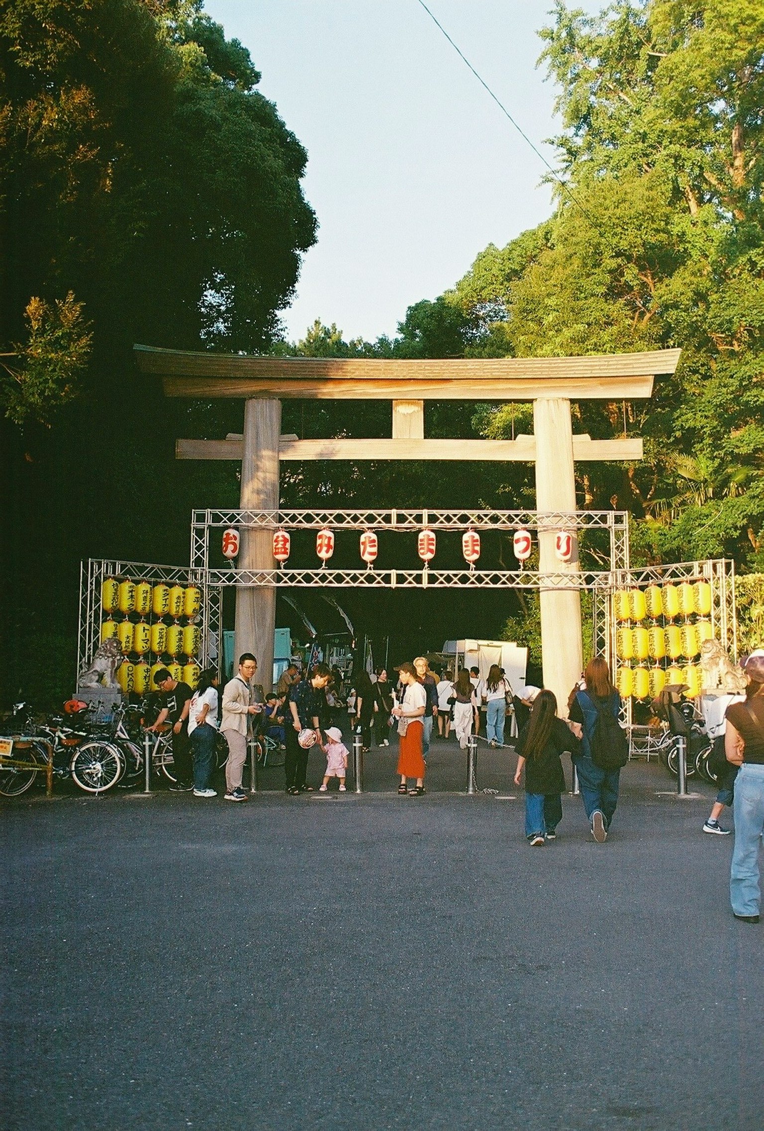 Kerumunan berkumpul di depan torii dengan dekorasi festival