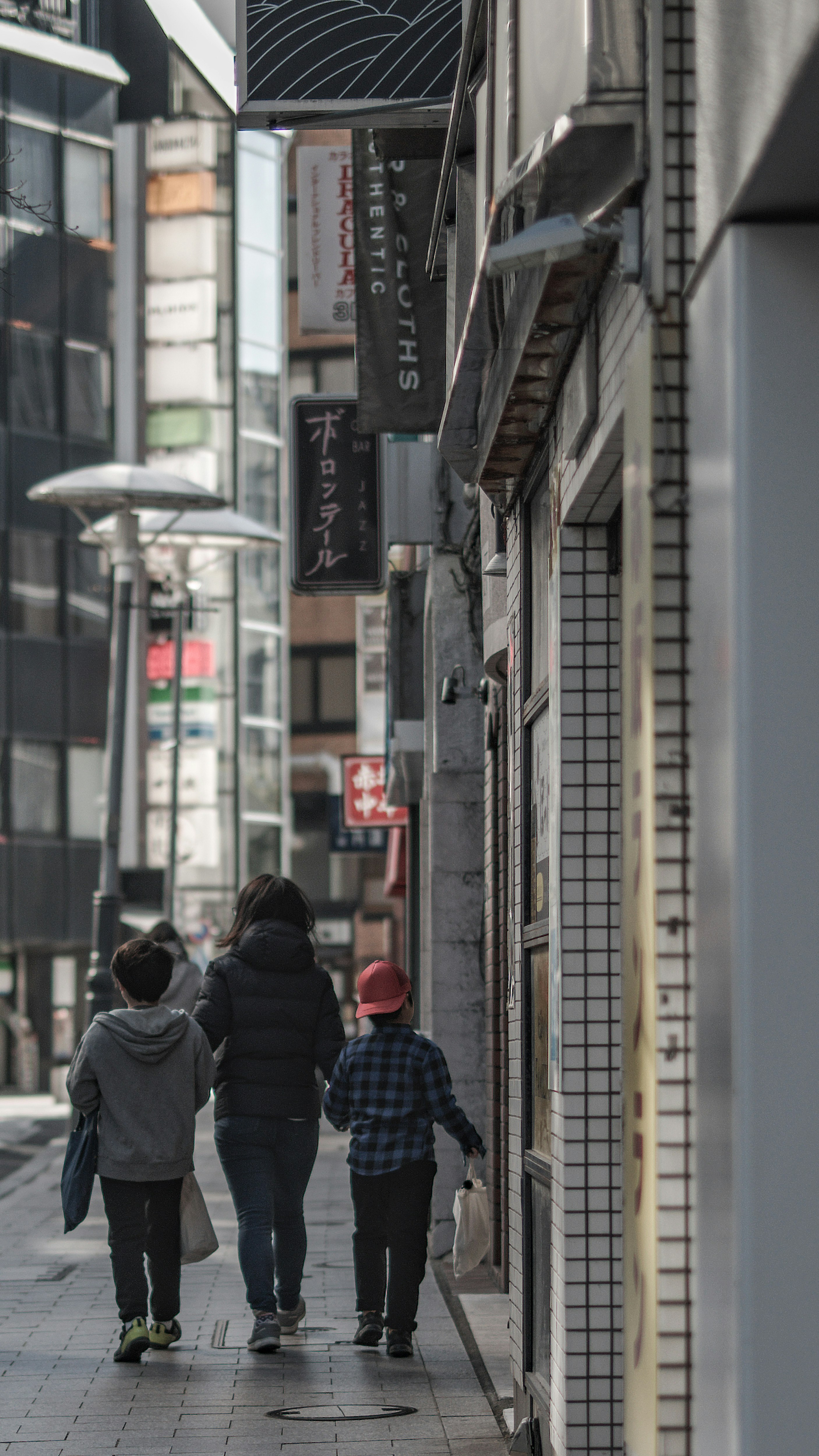 路地の商店街を歩く人々のある街並み