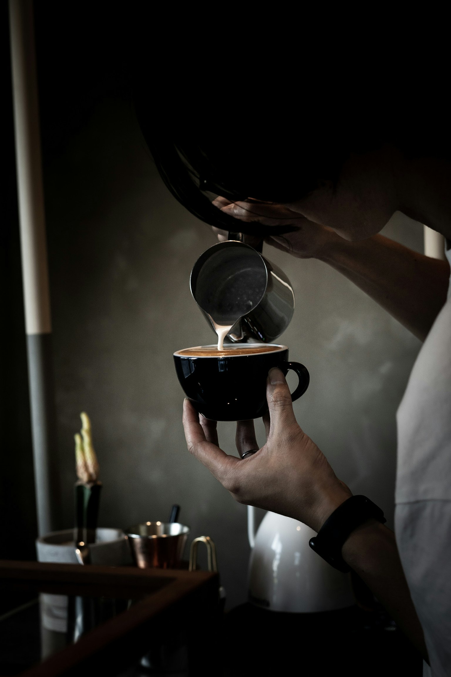 Barista che versa caffè in una tazza nera