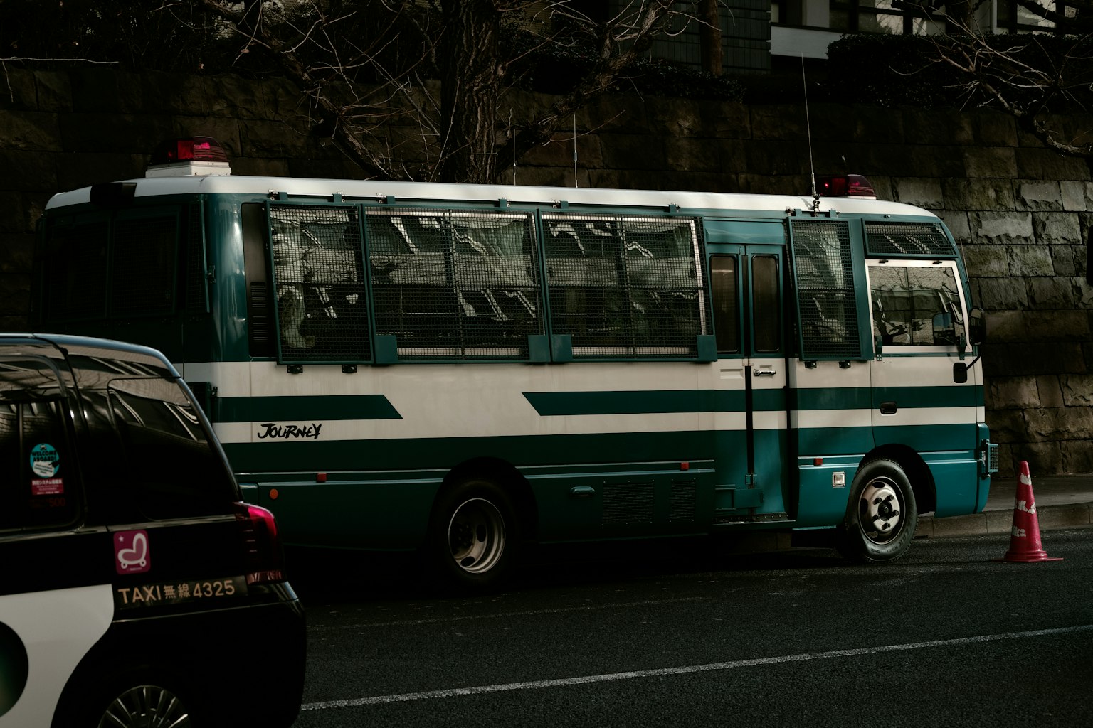 Sebuah bus biru dan putih diparkir di pinggir jalan