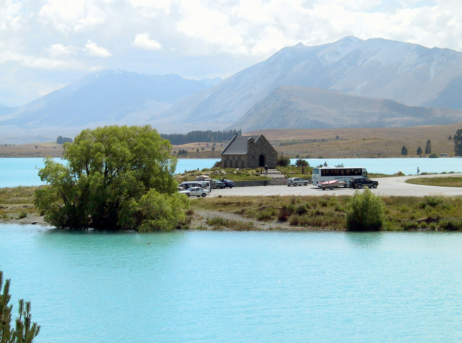 ทิวทัศน์ที่สวยงามของบ้านเล็กๆ ข้างทะเลสาบสีฟ้าครามที่มีภูเขาเป็นฉากหลัง