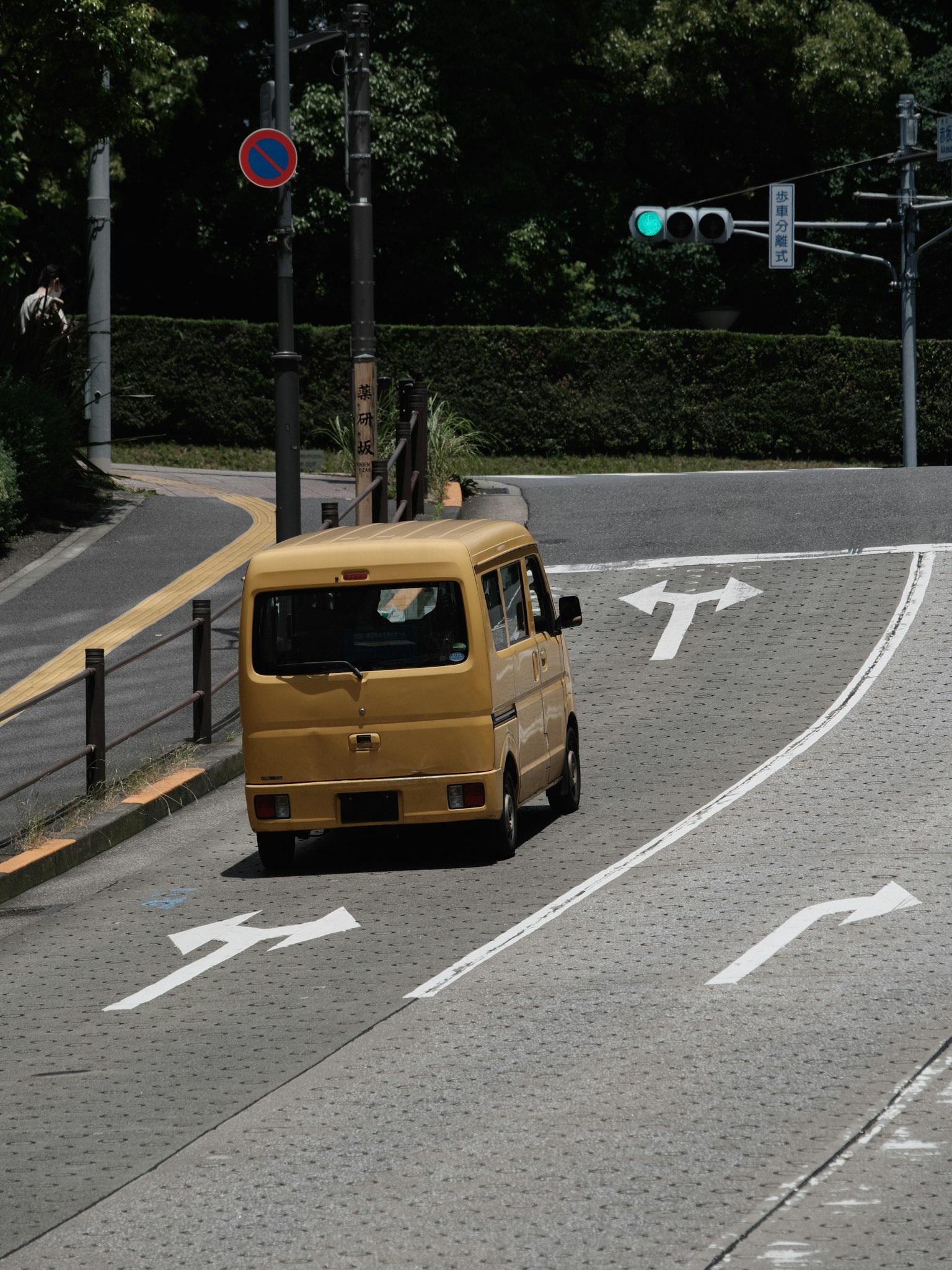 Mobil van kuning berbelok di sudut jalan di Jepang