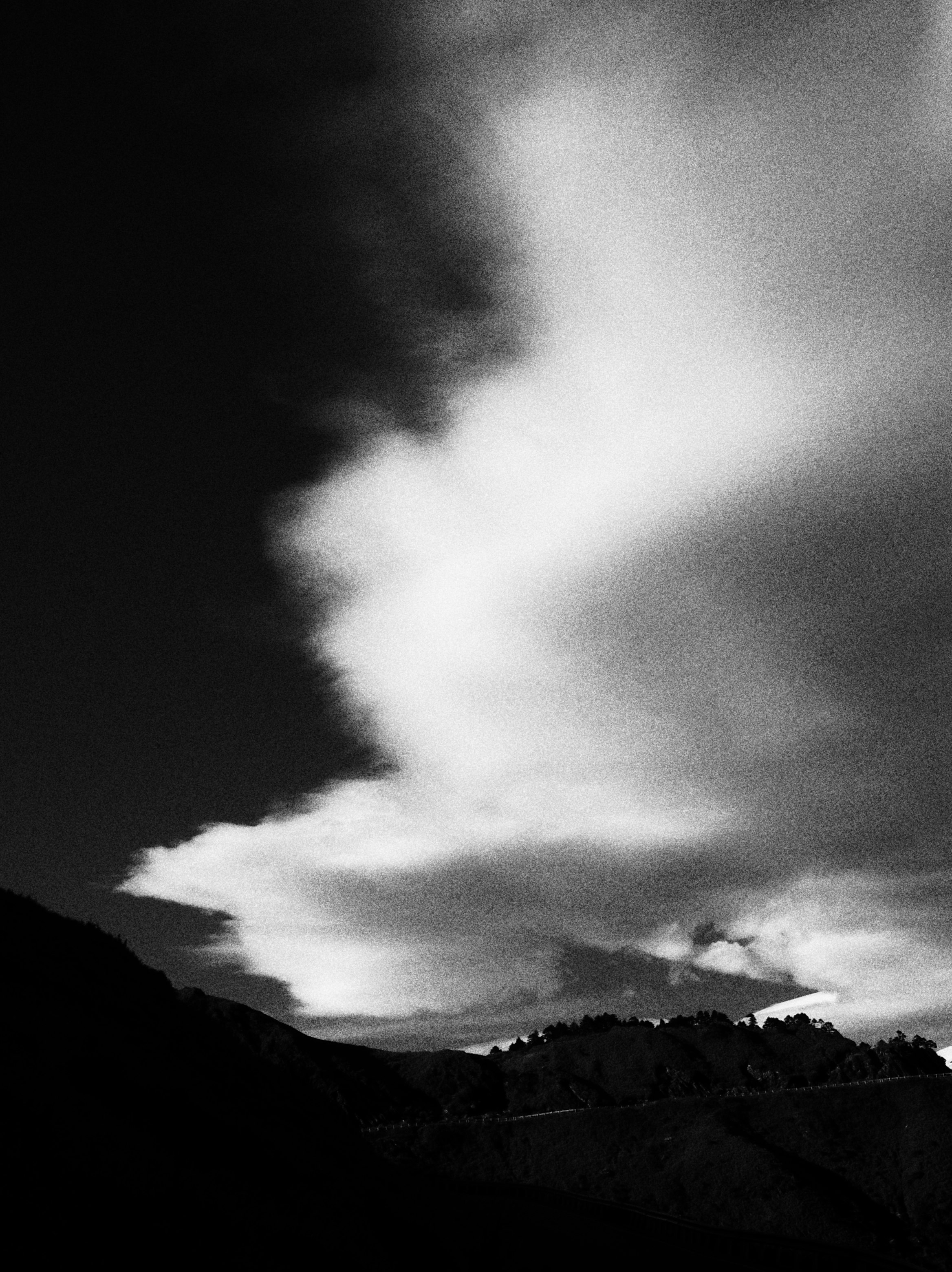 山稜にかかる雲と夕景のモノクロ空