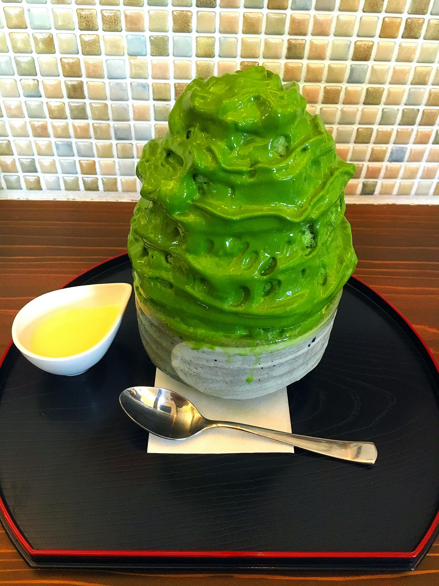 Green matcha shaved ice served in a bowl with a spoon