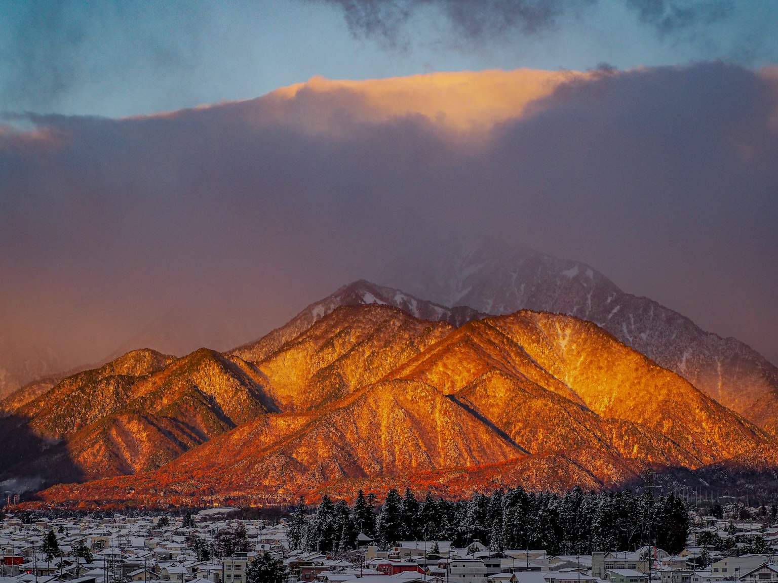 Impresionante vista de montañas iluminadas por el atardecer