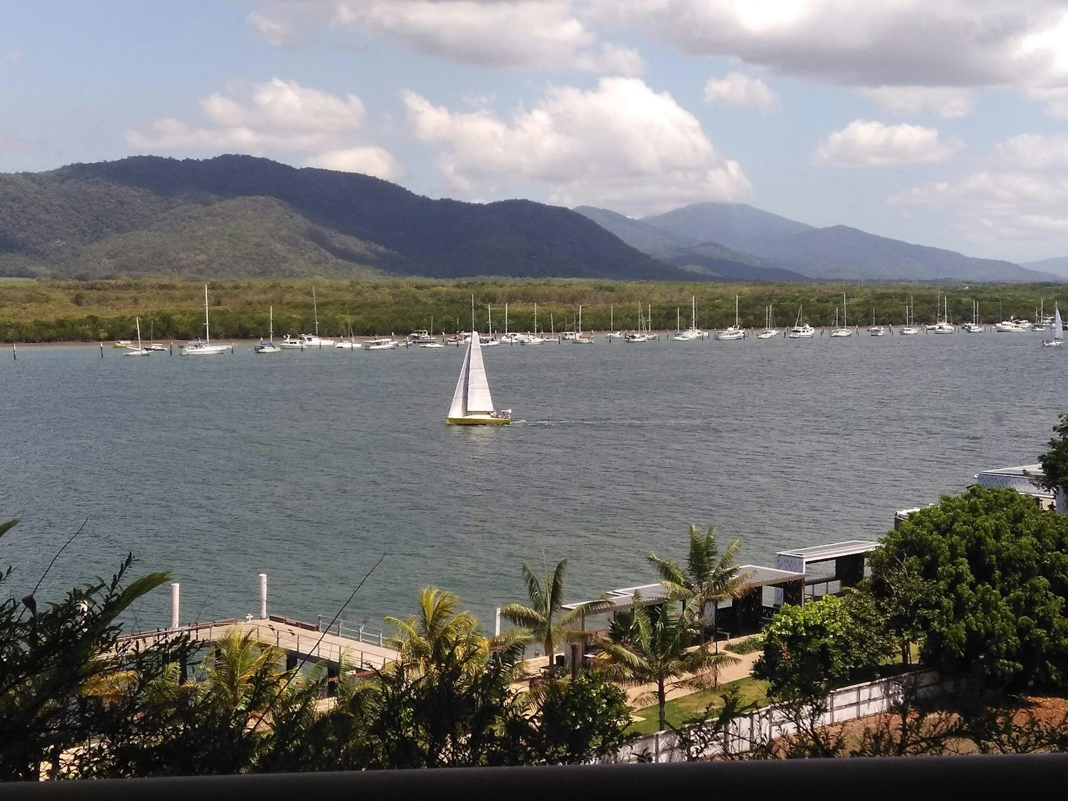 一幅河流的风景，背景有帆船和山脉