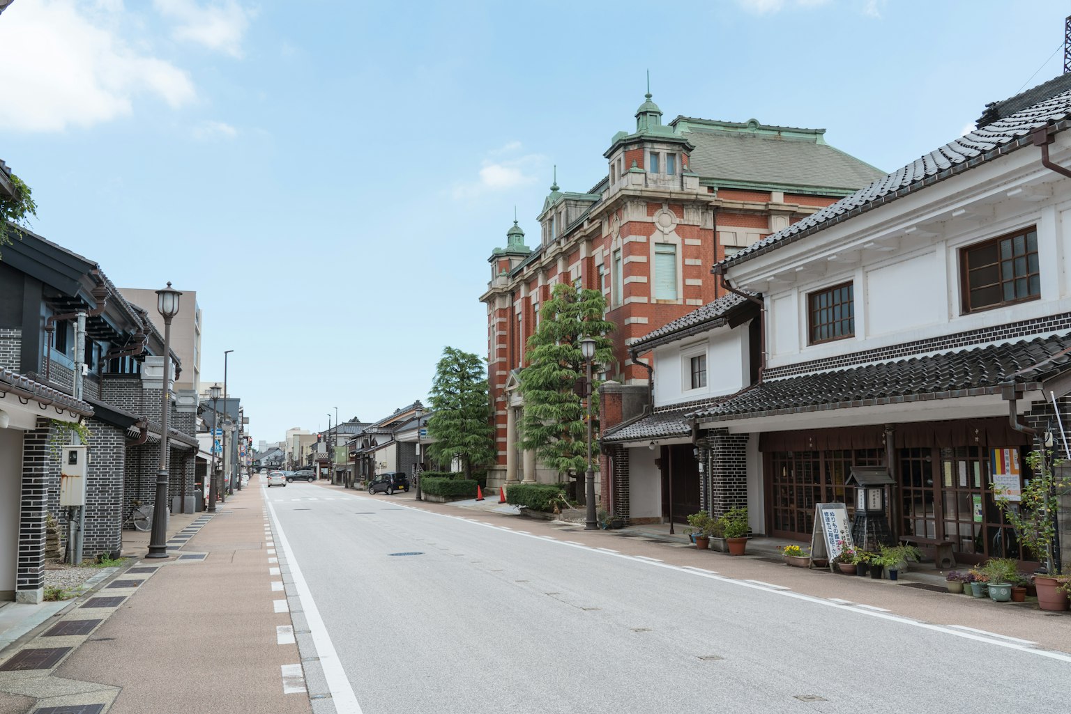 Quiet street featuring a historic building and traditional Japanese houses