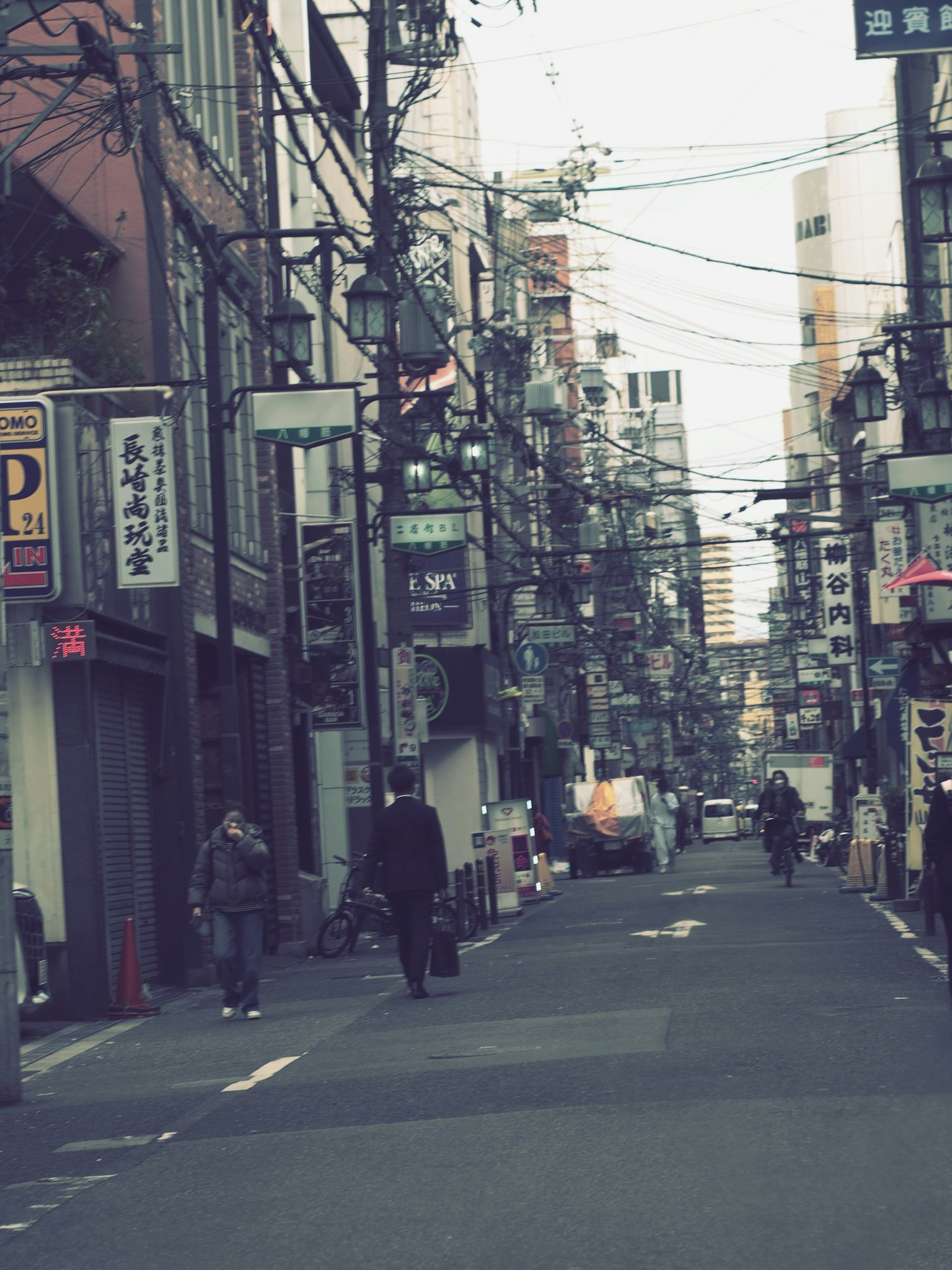 Quiet street in Tokyo featuring visible signs and overhead wires