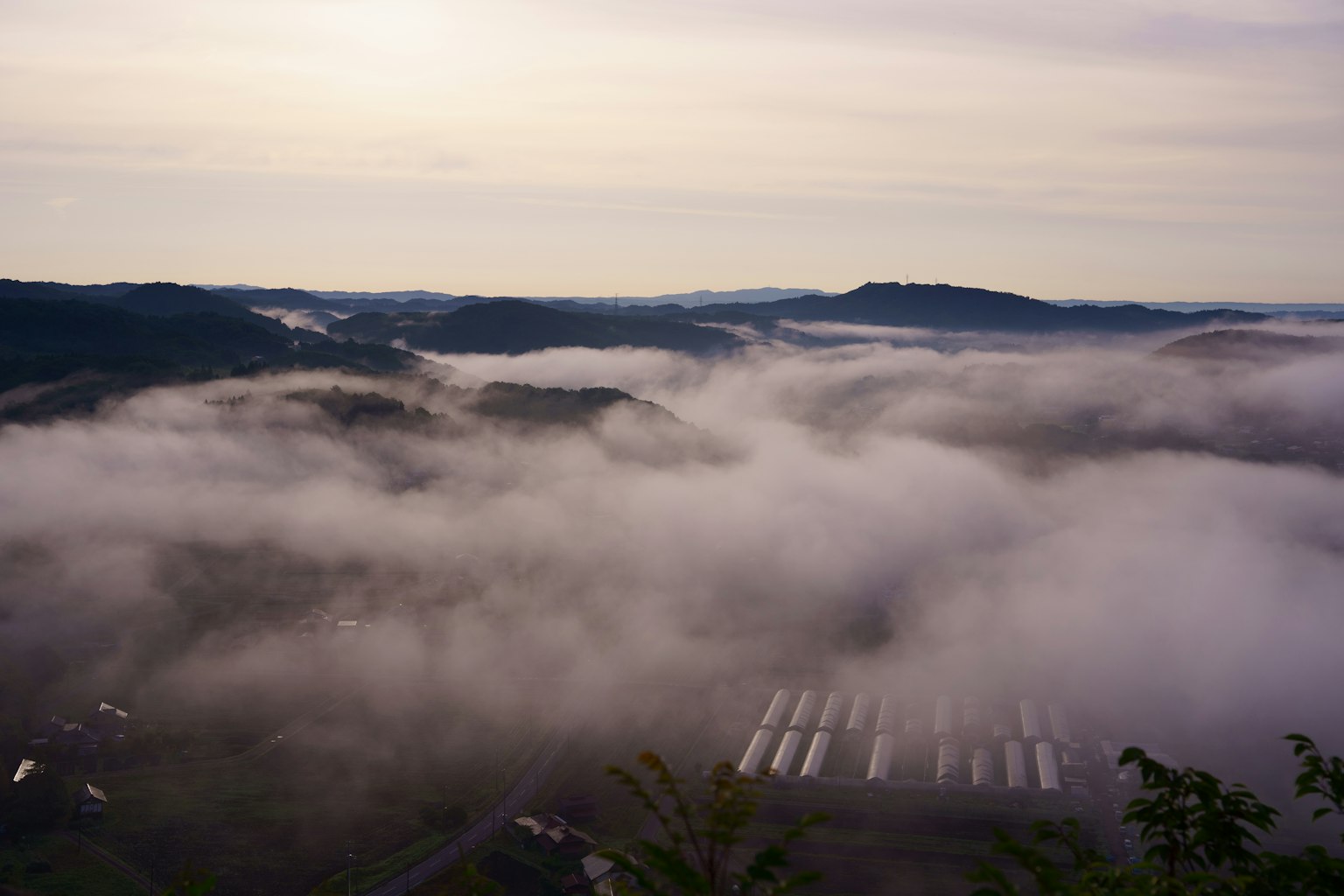 Pemandangan yang diselimuti kabut dengan gunung di latar belakang