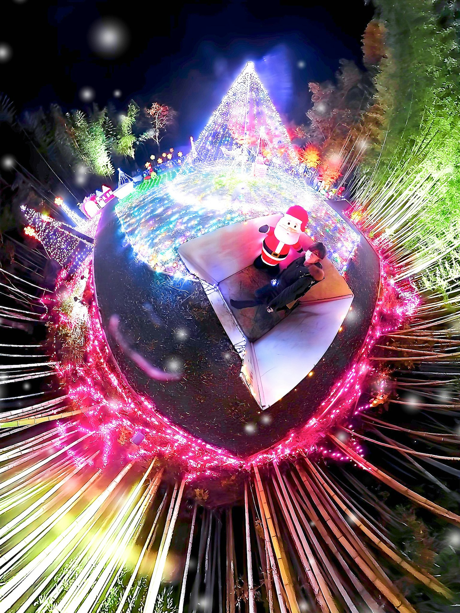 Fantasy landscape with Santa Claus and glowing Christmas tree surrounded by colorful lights
