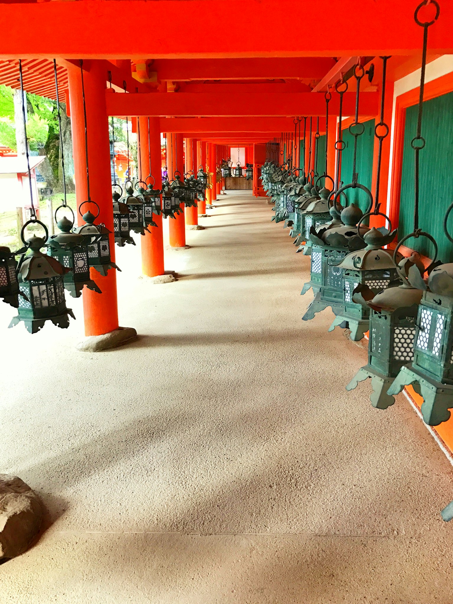 Rangée de lanternes en bronze sous des piliers rouges