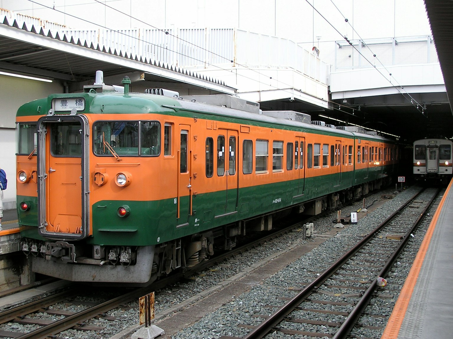 一列橙色和綠色的火車停在車站