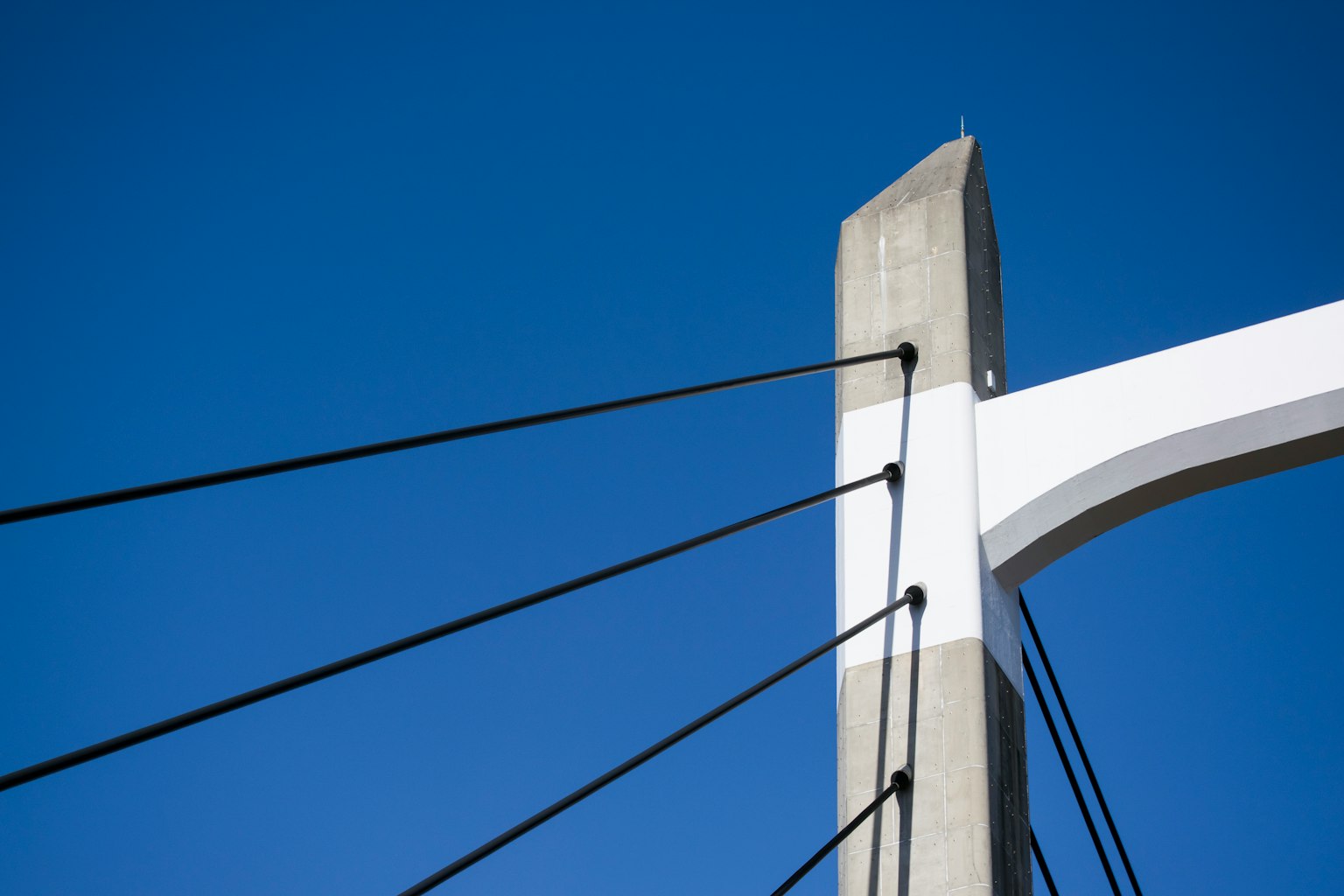 Dettaglio di un pilone di un ponte a sospensione su sfondo blu