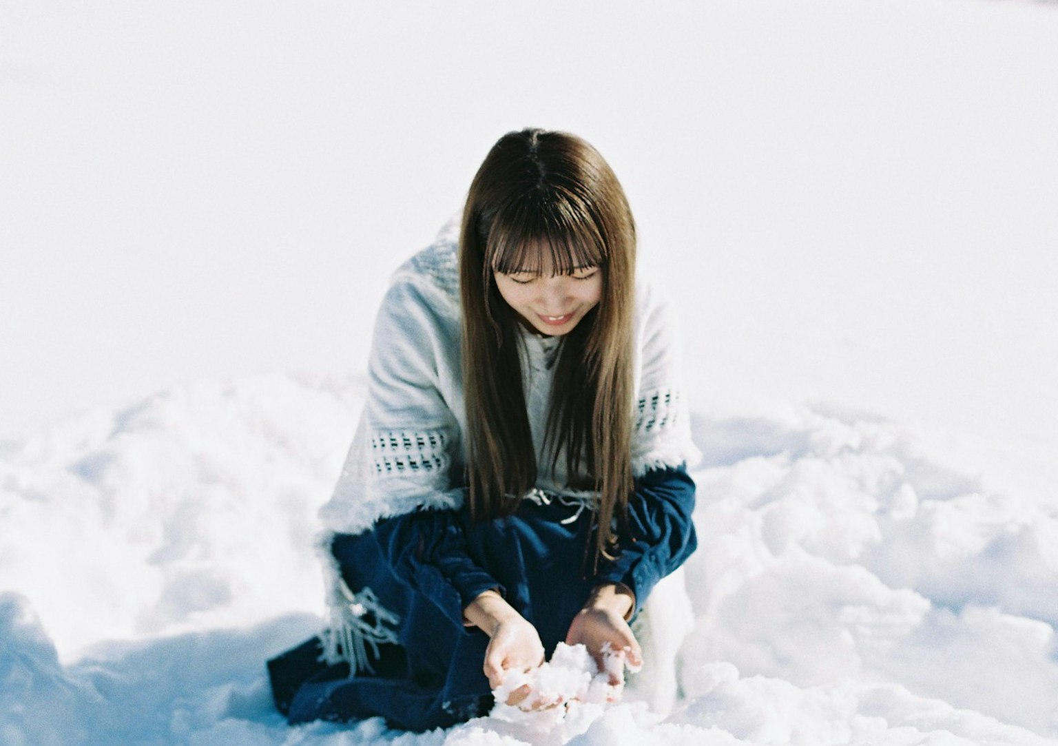 在雪中玩耍的女性长发穿着白色毛衣微笑
