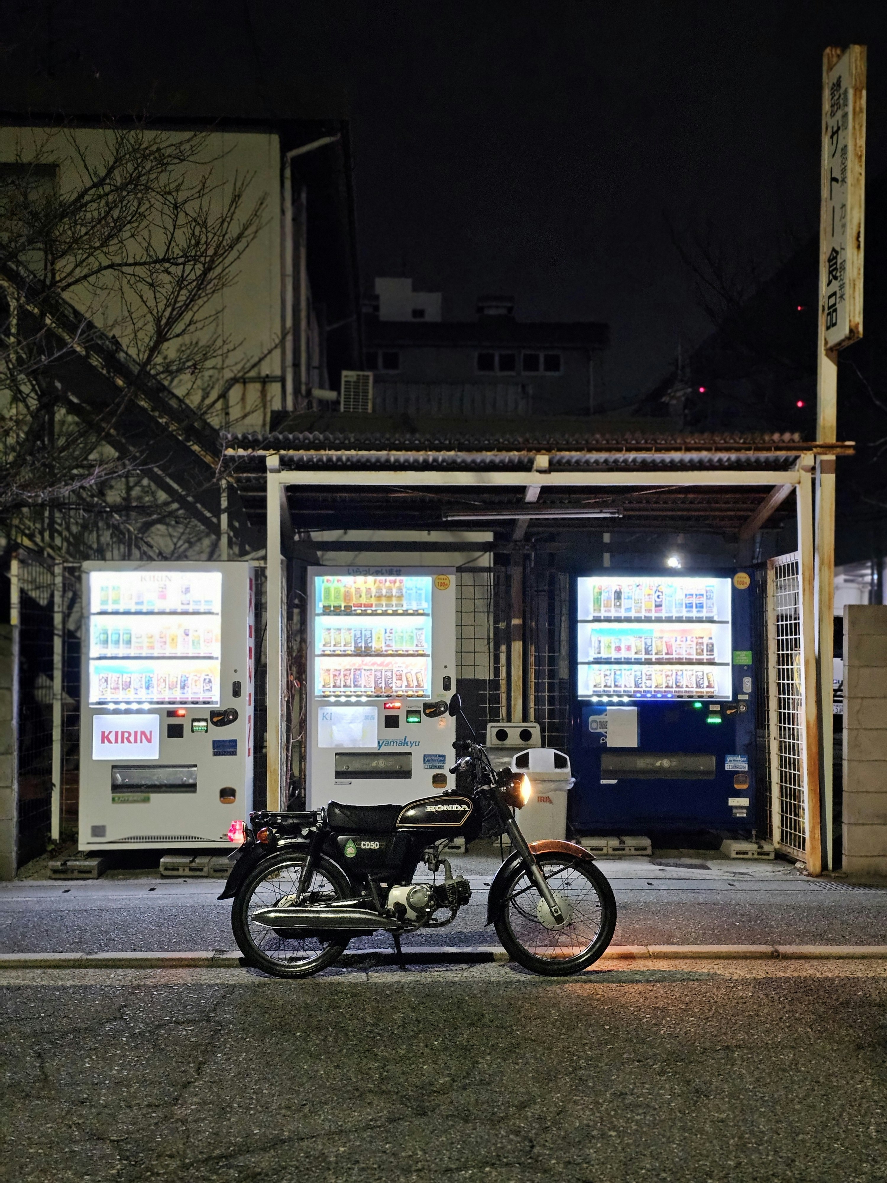Nächtliche Gasse mit Fahrrädern und Getränkautomaten