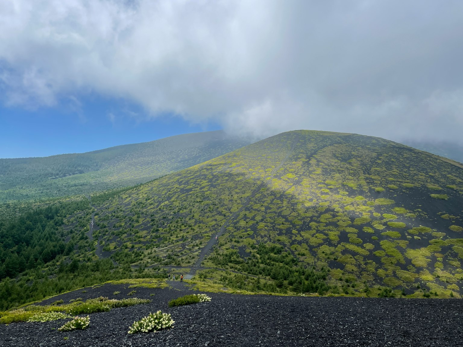 Vista escénica de colinas verdes bajo un cielo azul nublado