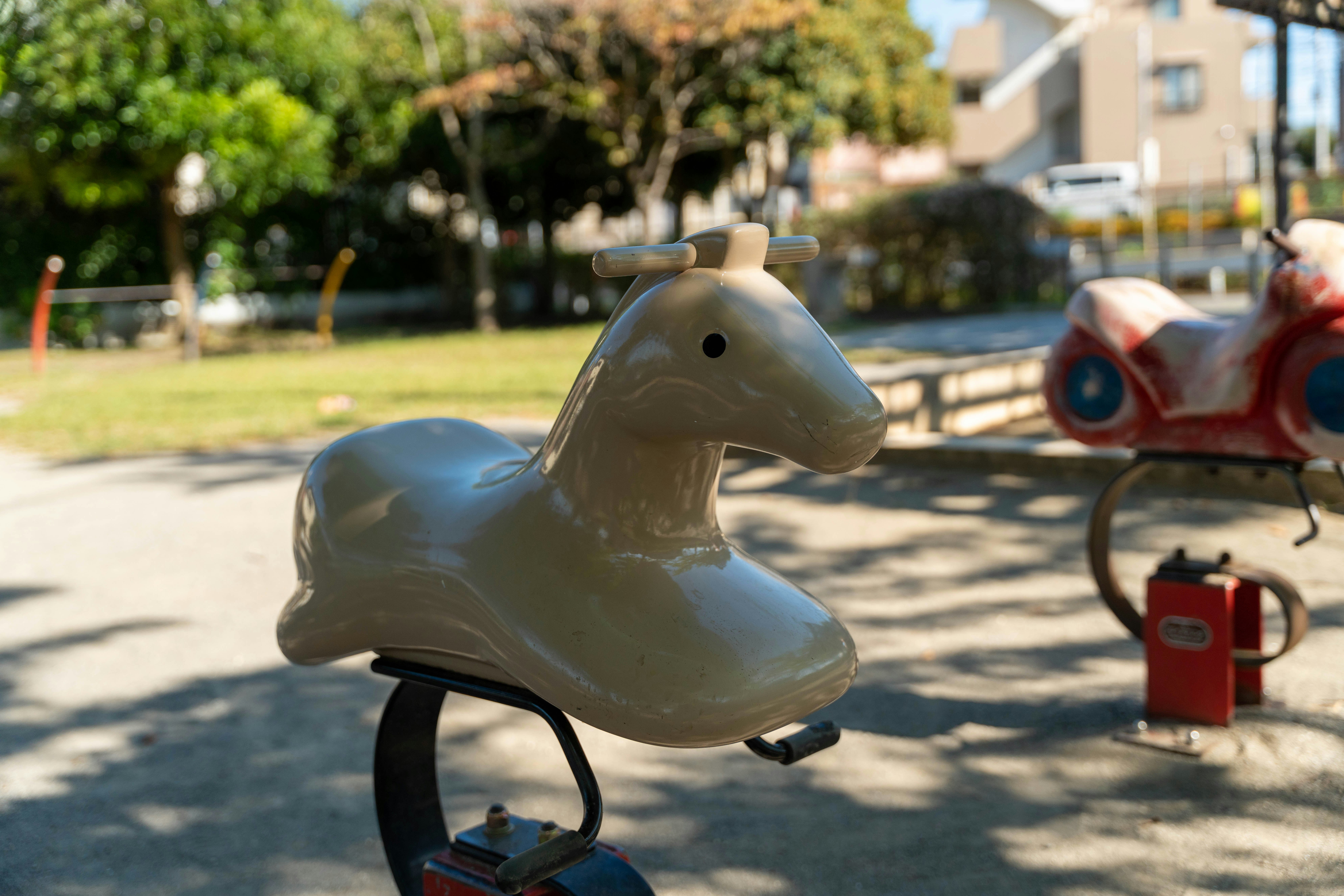 Juguete de montar en forma de caballo blanco en un parque