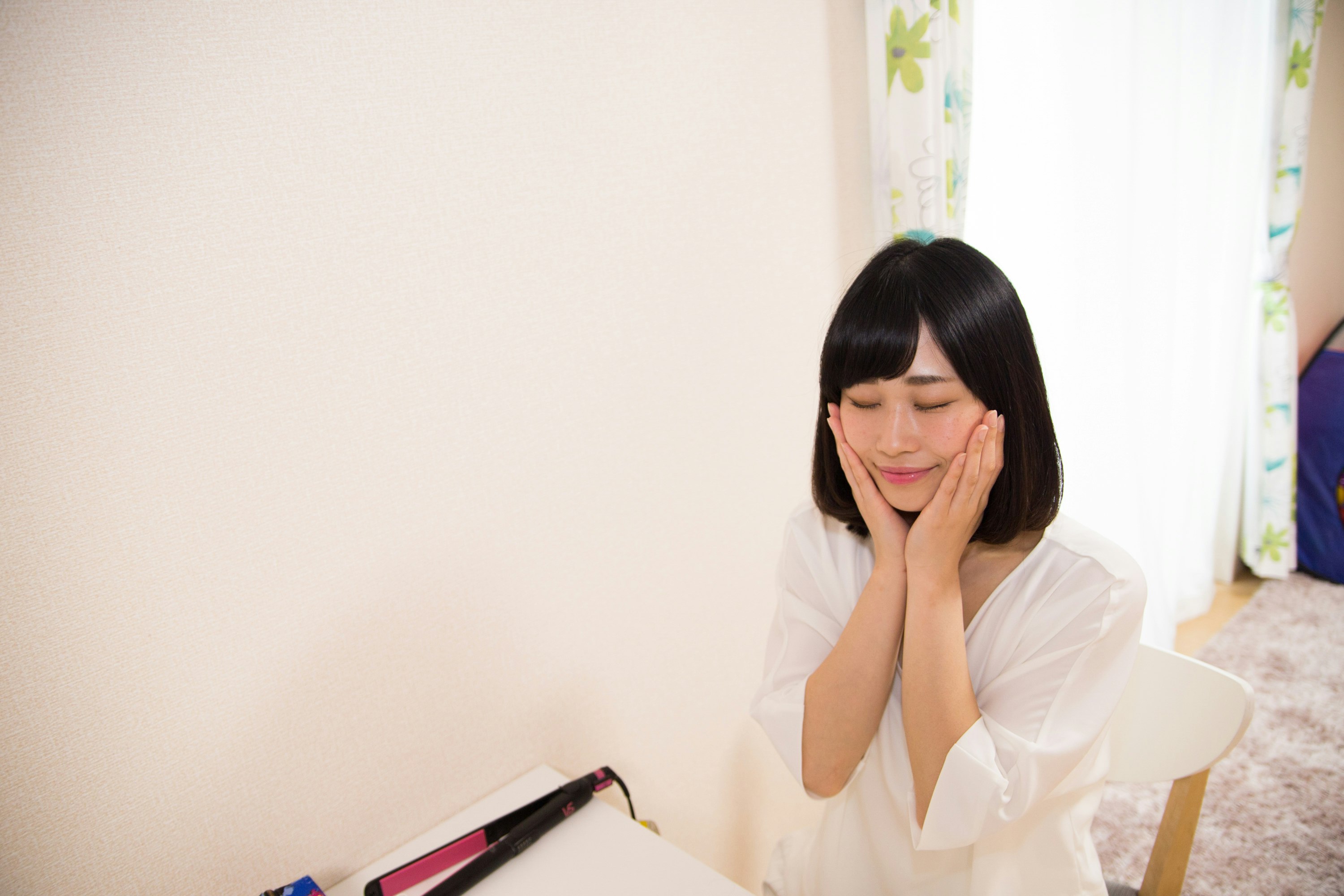 窓辺で本を前に考え込む女性