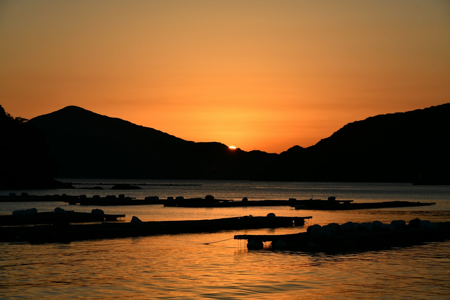 Silhouette magnifique du coucher de soleil sur l'eau avec des montagnes