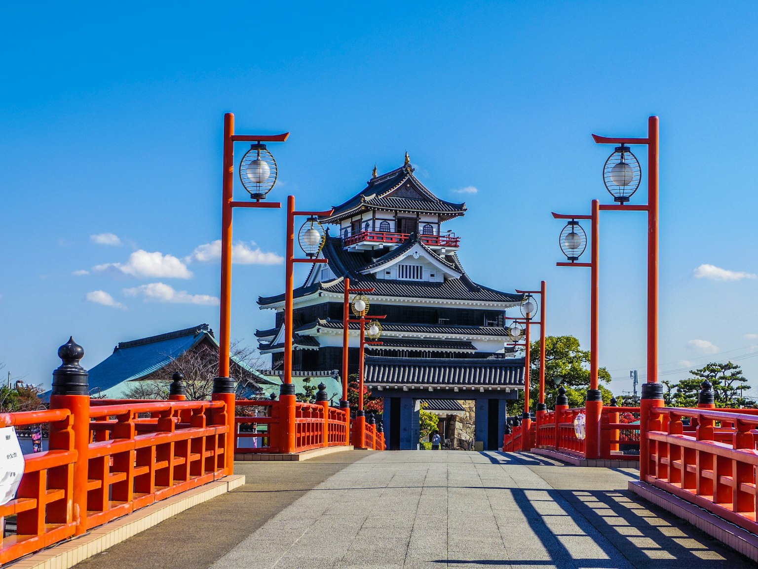 Château japonais avec un pont rouge et un ciel bleu