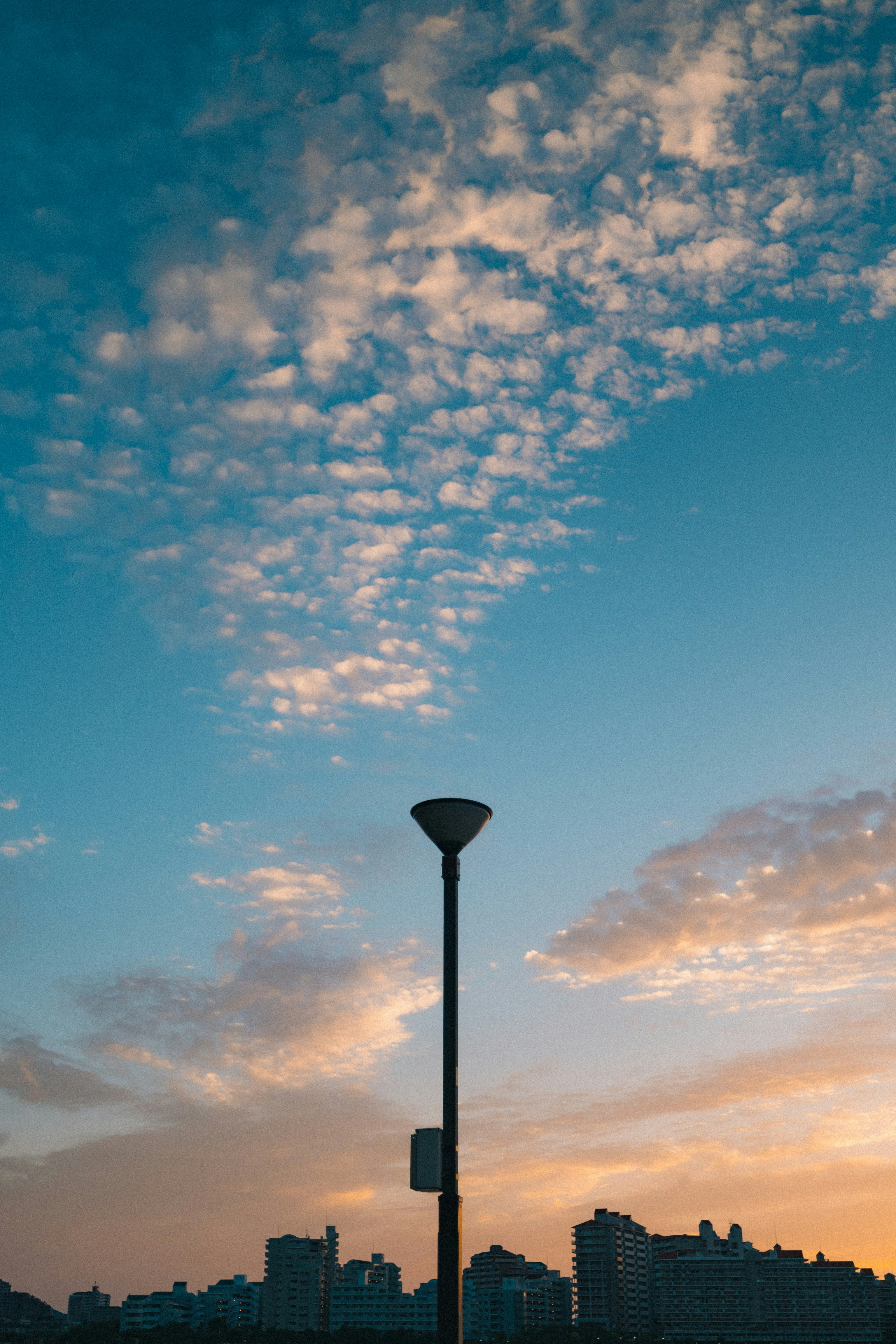 夕焼け空に伸びる街灯と雲の風景