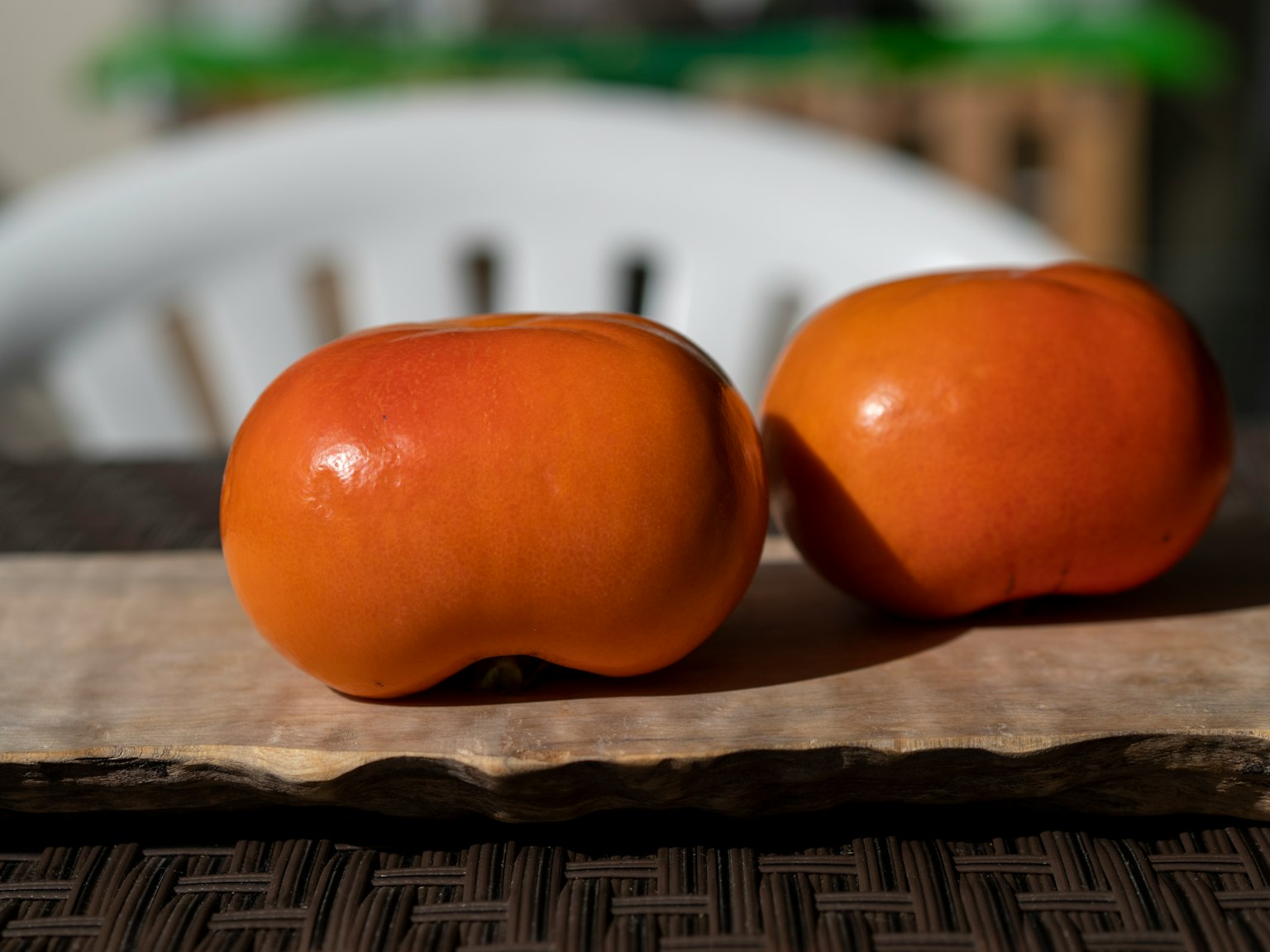 Dua buah oranye diletakkan di atas papan kayu